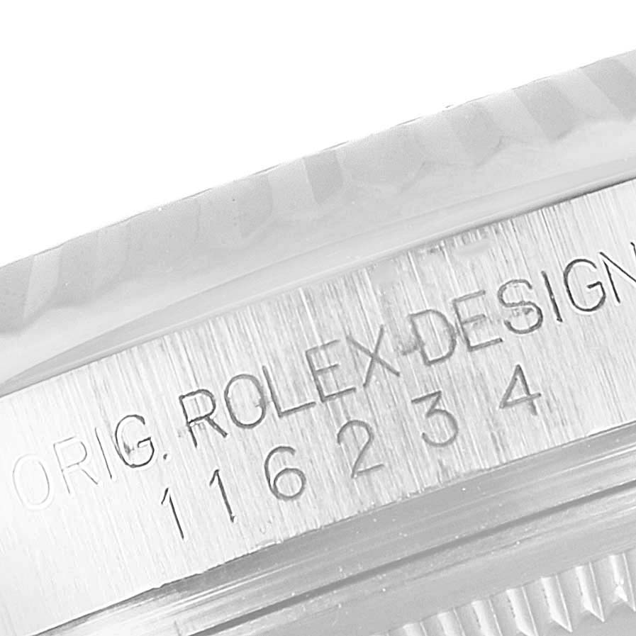 The image shows a close-up of the serial number and "ROLEX DESIGN" engraving on the case of a Rolex Datejust 116234 Men's Stainless Steel Silver Dial 116234 Men's Stainless Steel Silver Dial watch.