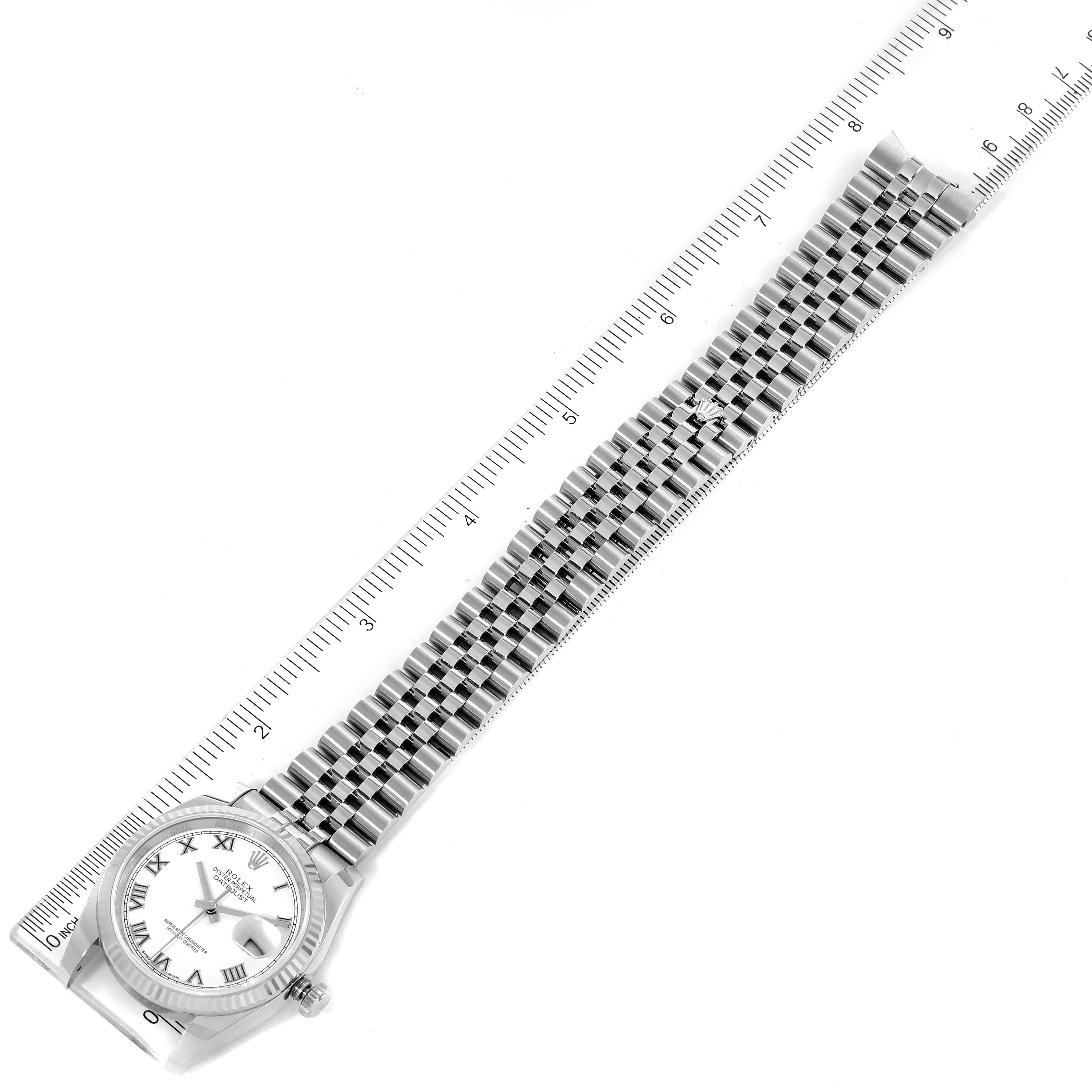 The image shows a Rolex Datejust 116234 Men
s Stainless Steel White Dial 116234 Men
s Stainless Steel White Dial watch laid flat with the face and entire bracelet visible next to a ruler.