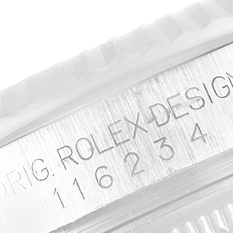 This close-up image shows part of the case with engraving of a Rolex Datejust 116234 Men
s Stainless Steel White Dial 116234 Men
s Stainless Steel White Dial watch, highlighting "ROLEX DESIGN" and the model number.