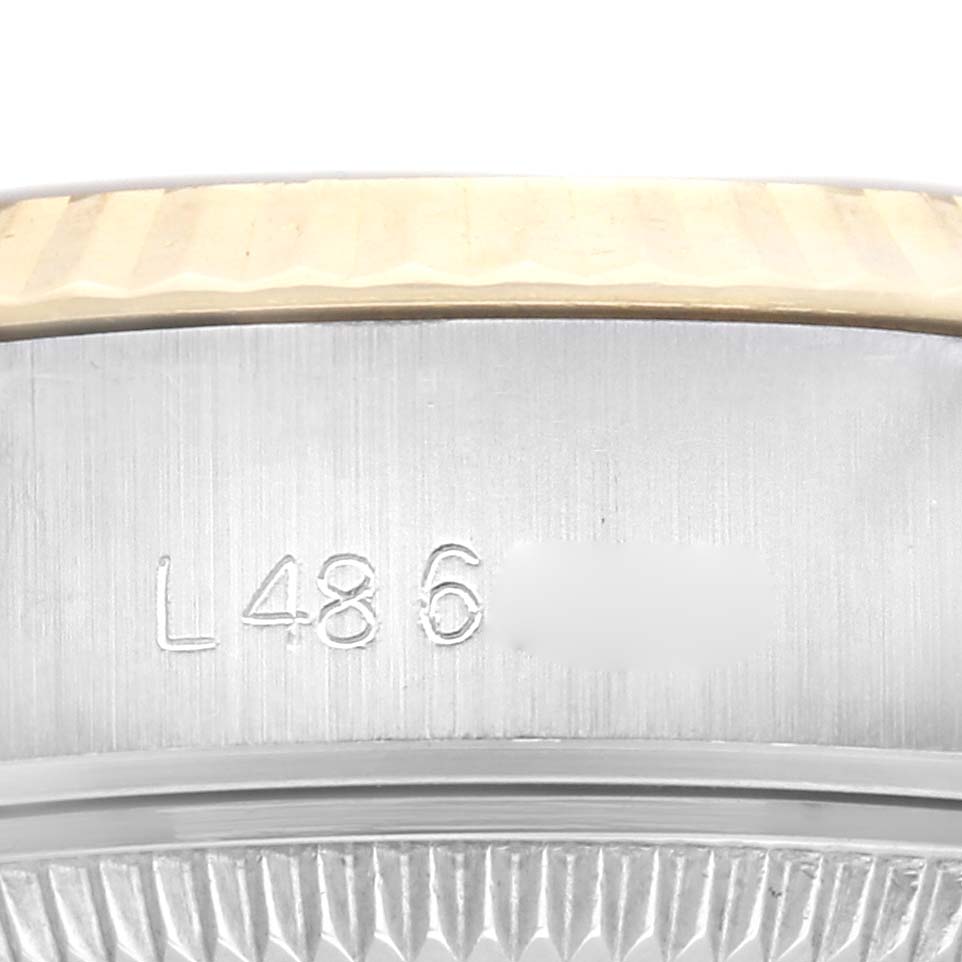 The image shows a close-up of the Rolex Datejust 69173 Women
s Steel and Gold (two tone) Champagne Dial 69173 Women
s Steel and Gold (two tone) Champagne Dial bezel and the engraved serial number on the case.