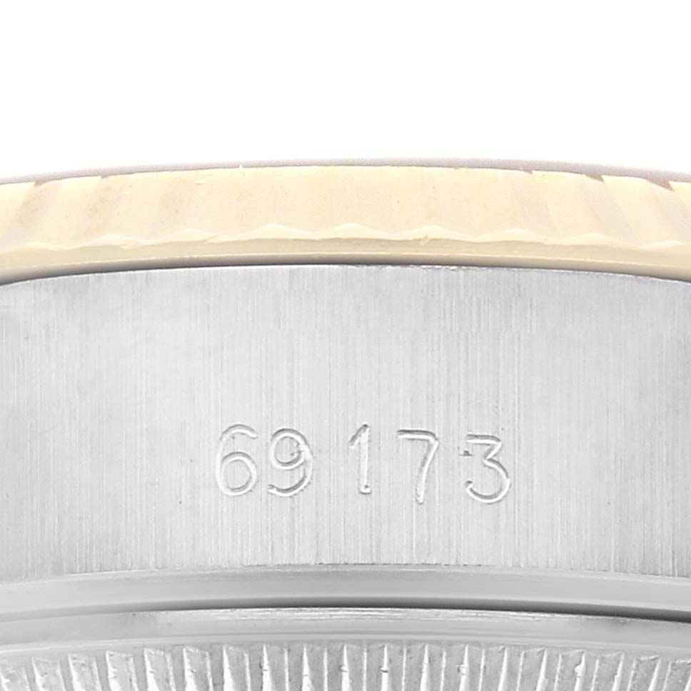 The image shows a close-up side view of a Rolex Datejust 69173 Women
s Steel and Gold (two tone) Champagne Dial 69173 Women
s Steel and Gold (two tone) Champagne Dial, focusing on the engraved reference number.