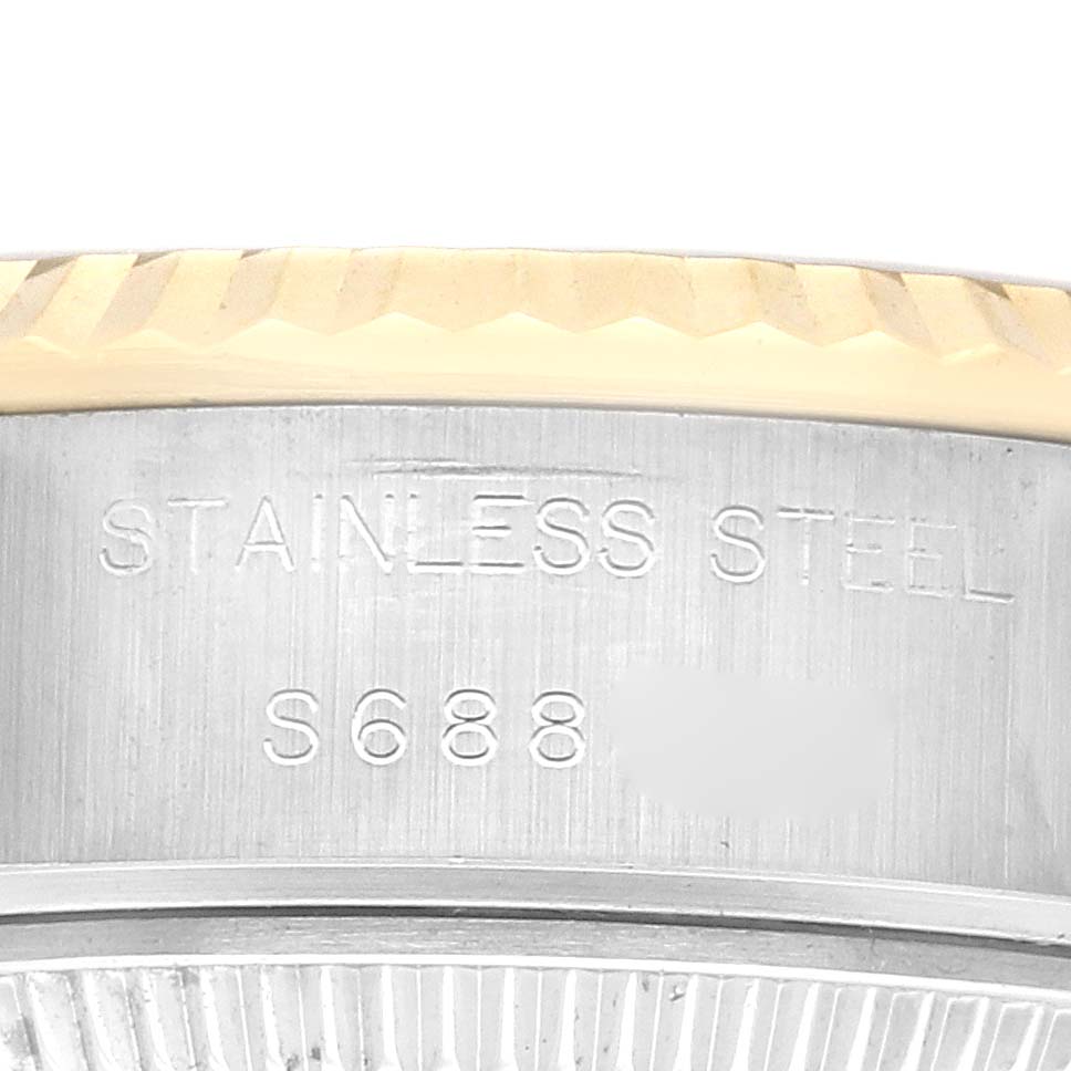 The image shows a close-up of the side of a Rolex Datejust 69173 Women
s Steel and Gold (two tone) Champagne Dial 69173 Women
s Steel and Gold (two tone) Champagne Dial, highlighting the stainless steel case and the edge of the bezel.