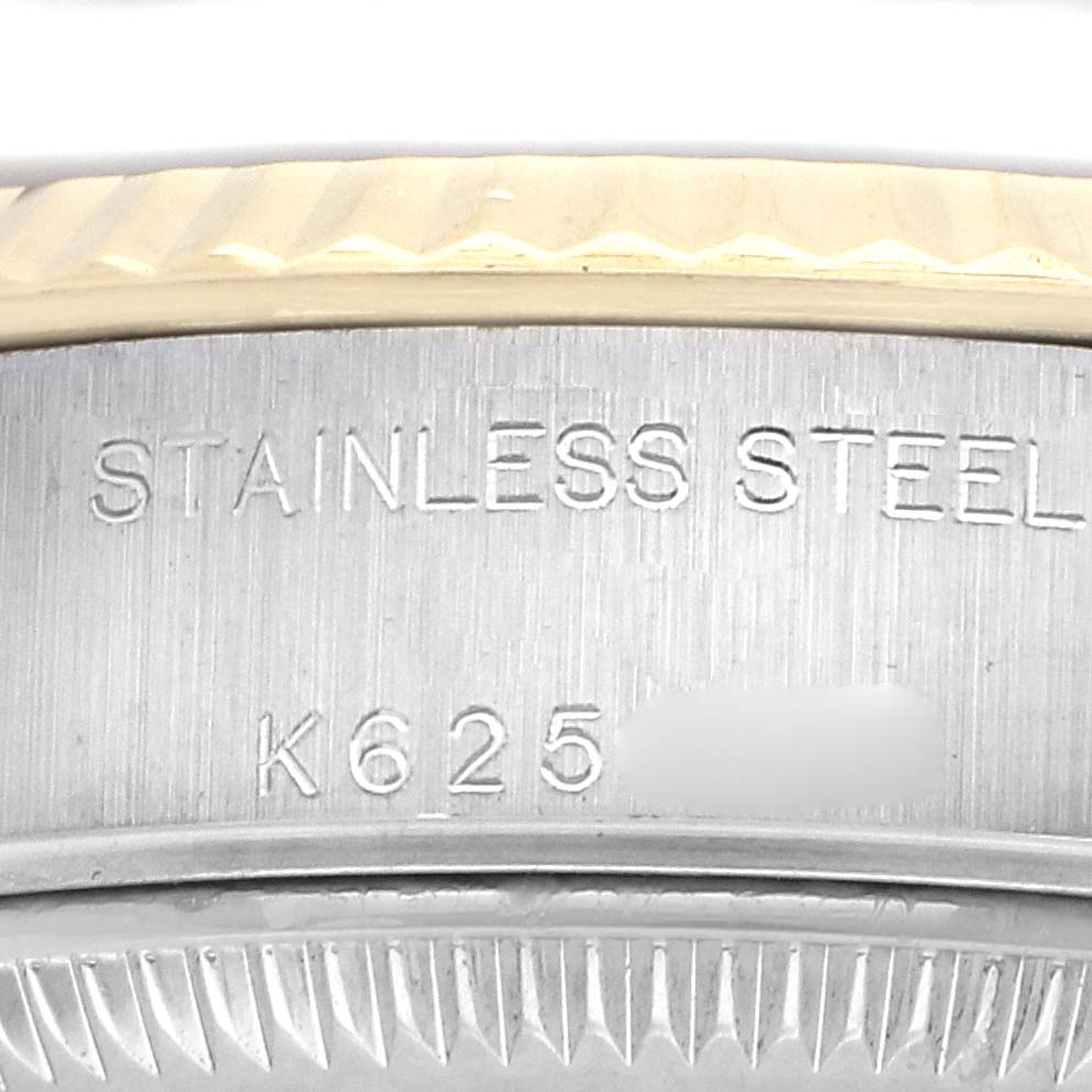 The image shows a close-up of the metal edge with engraved text of a Rolex Datejust 79173 Women
s Steel and Gold (two tone) Black Dial 79173 Women
s Steel and Gold (two tone) Black Dial watch, featuring the bezel and case side.
