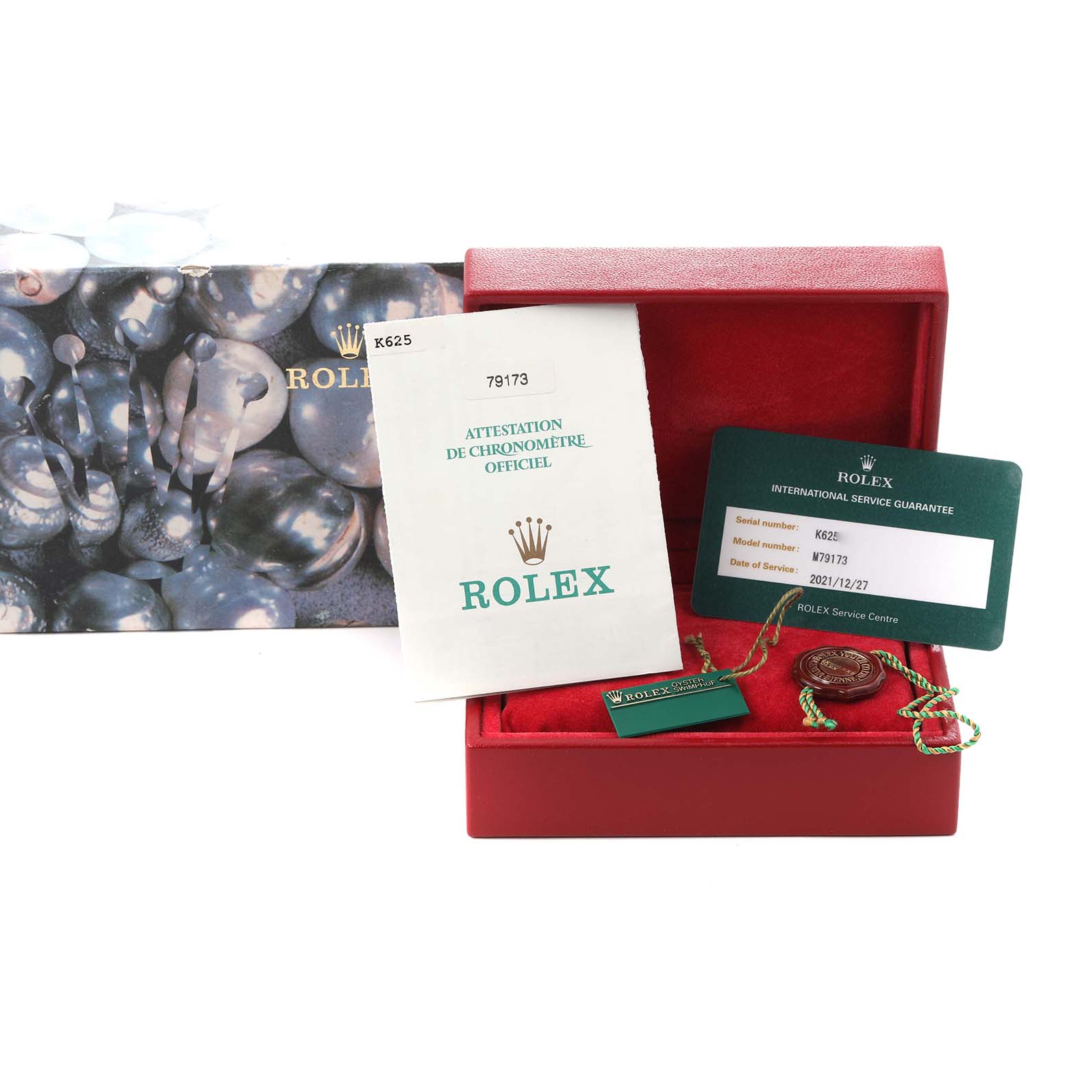 The image shows a Rolex Datejust 79173 Women
s Steel and Gold (two tone) Black Dial 79173 Women
s Steel and Gold (two tone) Black Dial box with documentation and tags, viewed from the top.