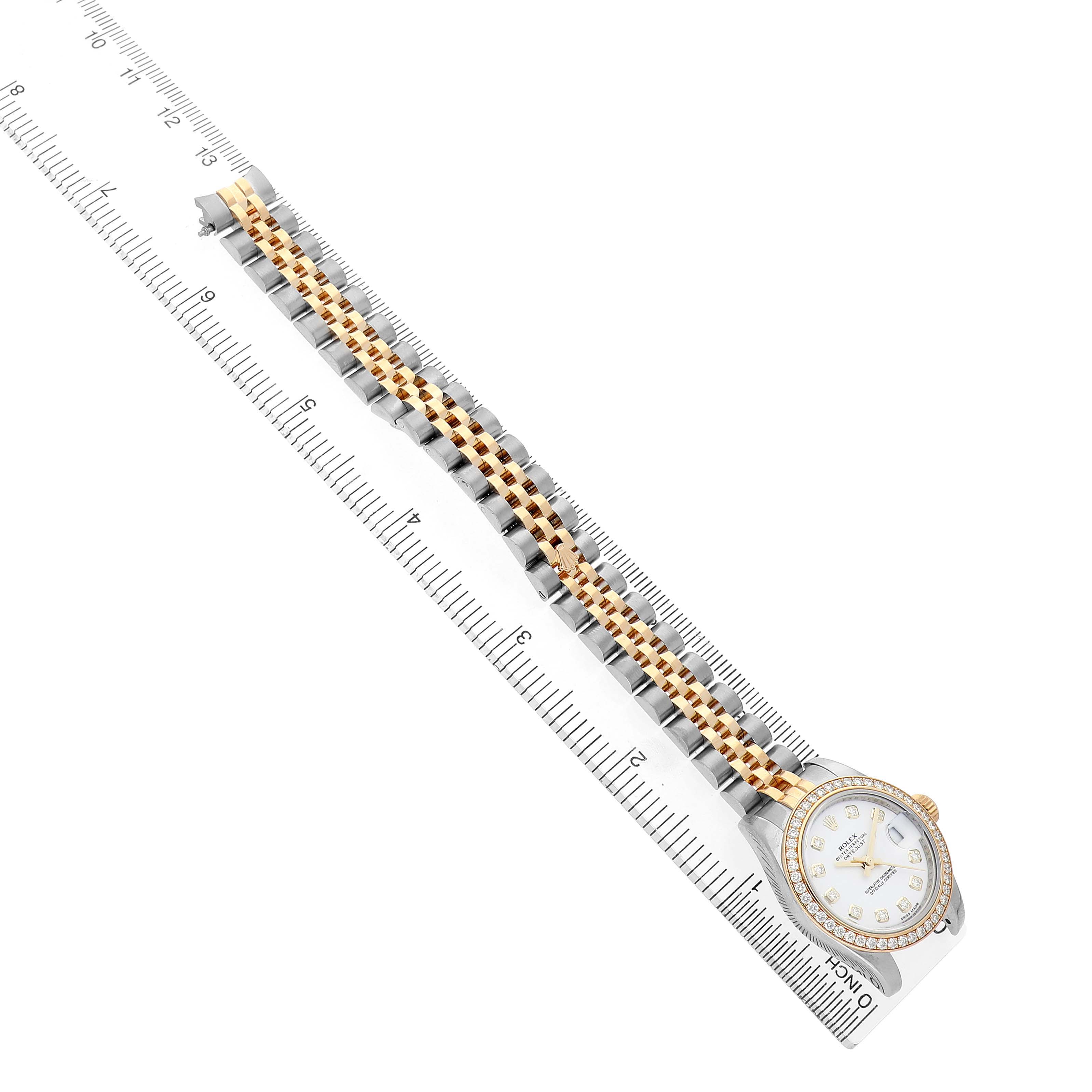 The Rolex Datejust 179383 Women's Steel and Gold (two tone) White Dial watch is shown from a top view, highlighting the face and full-length two-tone bracelet alongside a ruler.