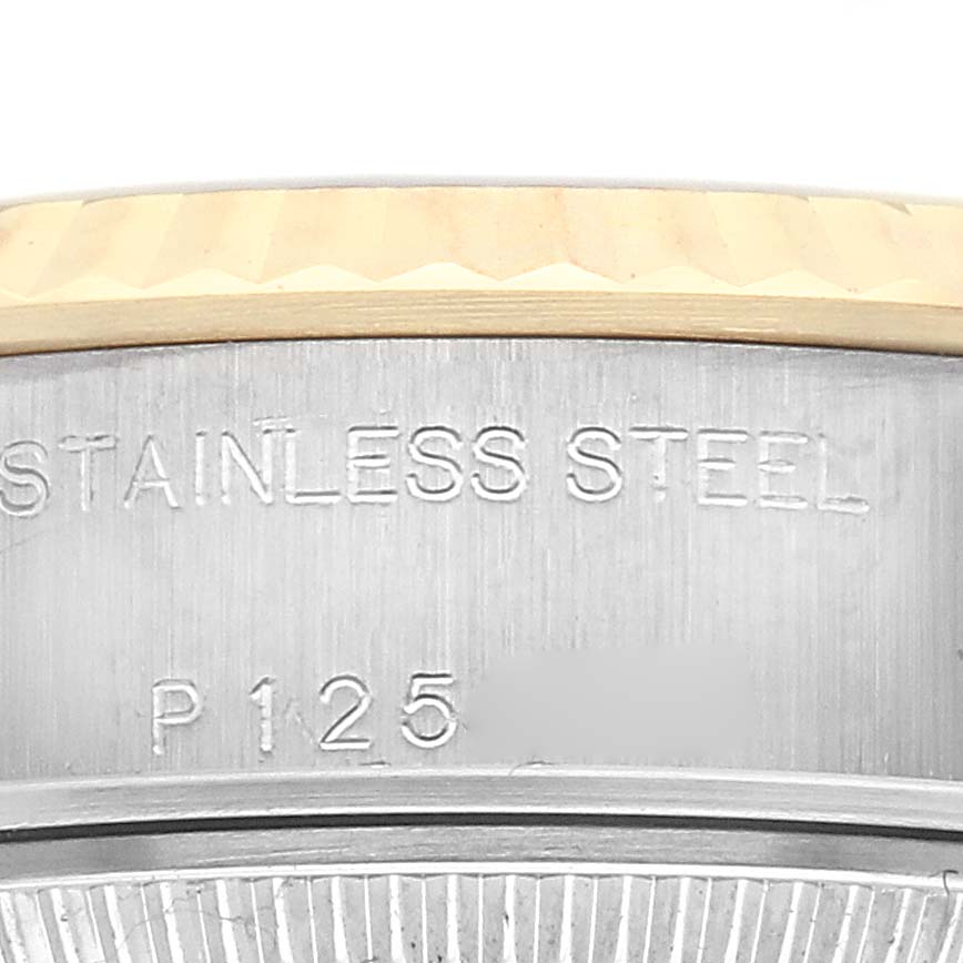 The image shows a close-up of the side of the Rolex Datejust 79173 Women
s Steel and Gold (two tone) White Dial 79173 Women
s Steel and Gold (two tone) White Dial, highlighting the bezel and engraved markings.
