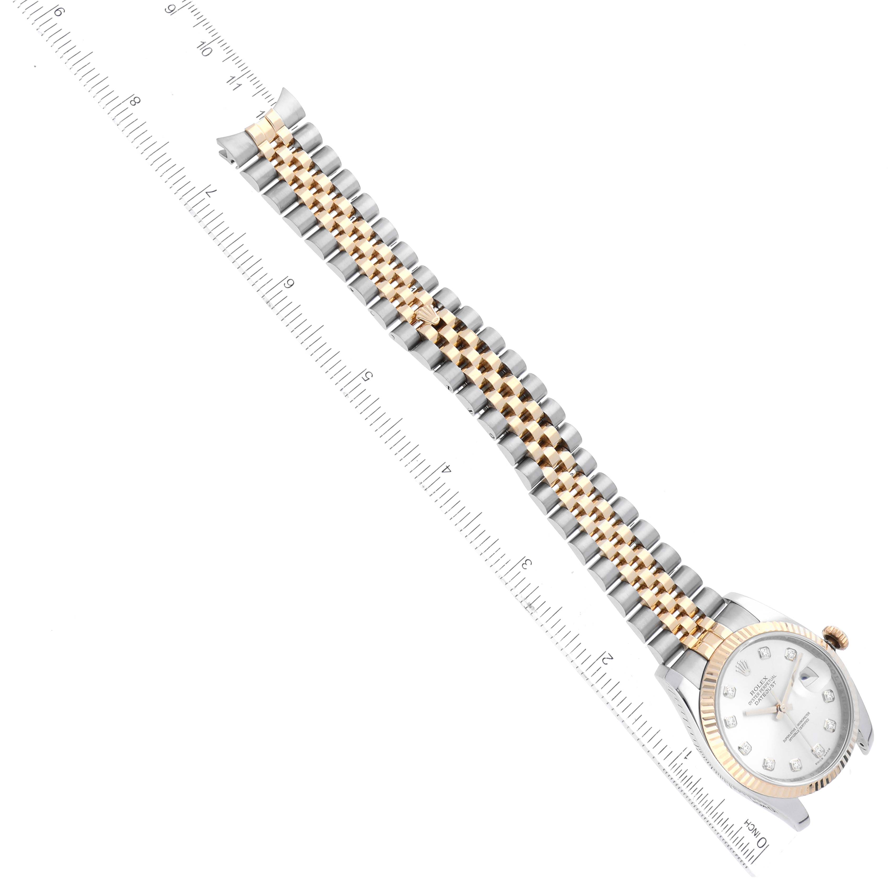 This image shows a Rolex Datejust 116233 Men's Steel and Gold (two tone) Silver Dial 116233 Men's Steel and Gold (two tone) Silver Dial watch at an angle, highlighting its bracelet, dial, and bezel alongside a measuring ruler.