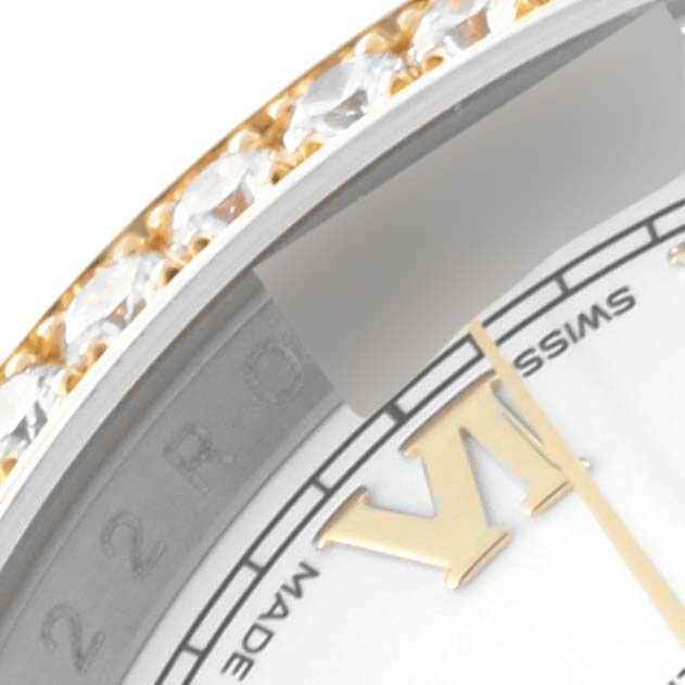 This close-up image of the Rolex Datejust 116243 Men's Steel and Gold (two tone) White Dial 116243 Men's Steel and Gold (two tone) White Dial model shows part of the bezel with gemstones and a portion of the dial with hour markers.