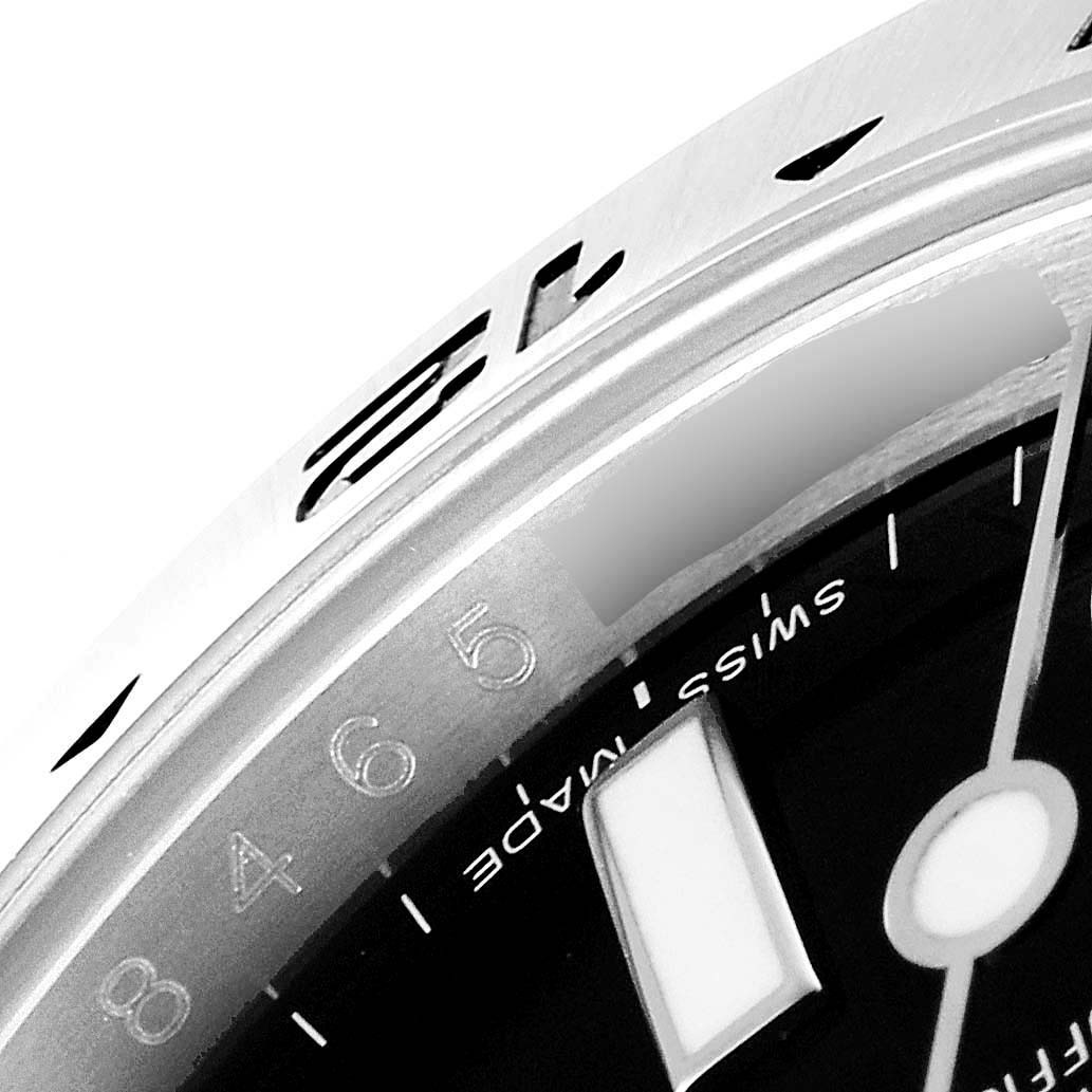 This close-up image of a Rolex Explorer 216570 Men's Stainless Steel Black Dial 216570 Men's Stainless Steel Black Dial watch shows the bezel, part of the dial, and hour markers.