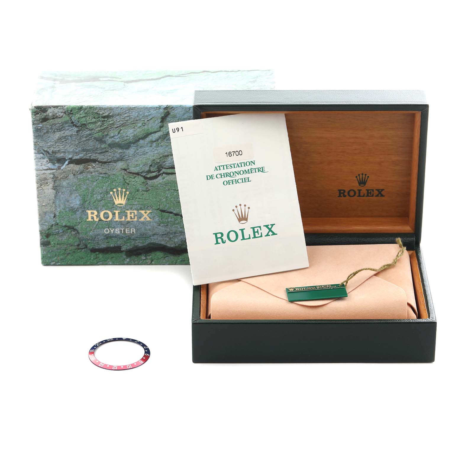 The image shows a Rolex GMT-Master 16700 Men
s Stainless Steel Black Dial 16700 Men
s Stainless Steel Black Dial box with a bezel insert, a certificate, and packaging materials.