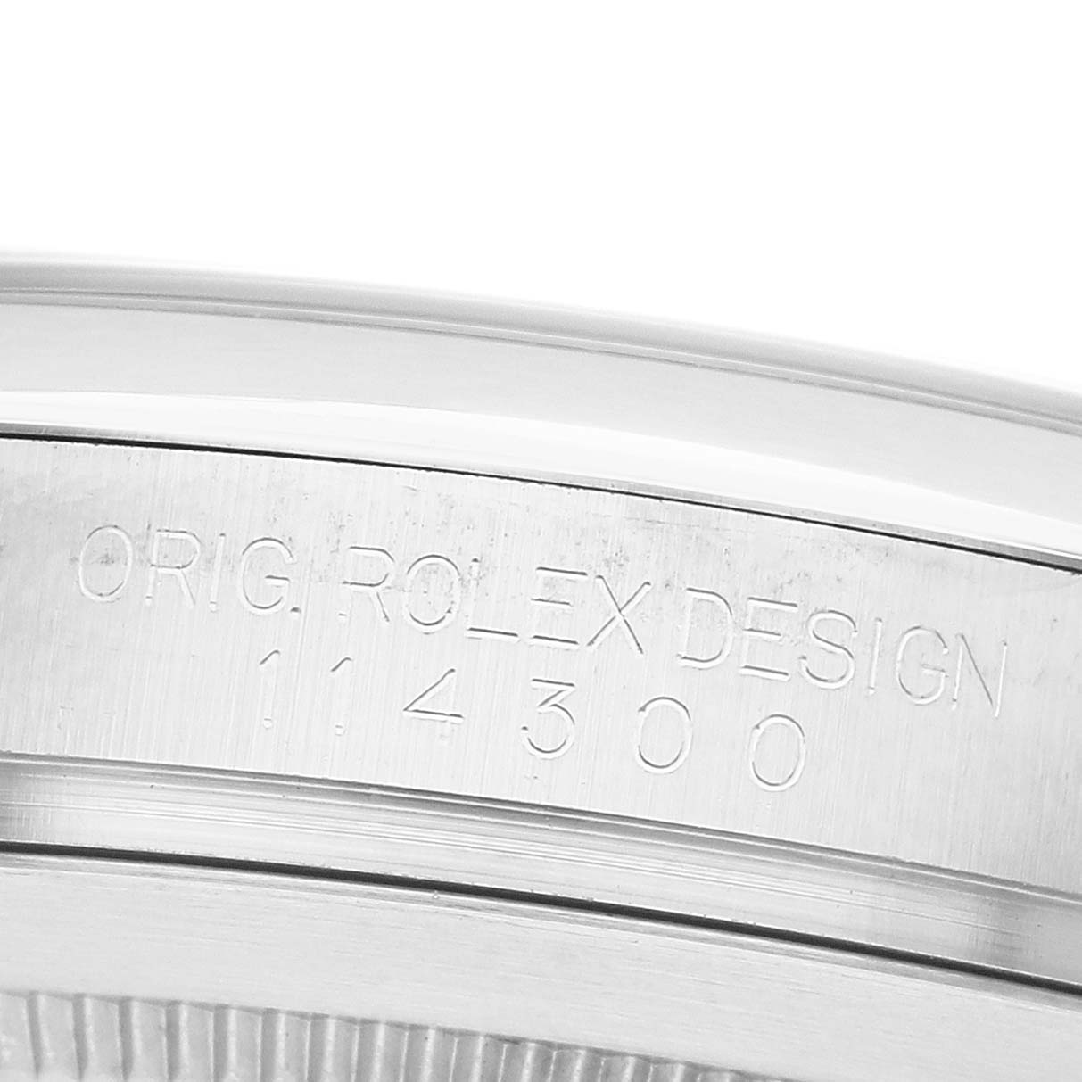 The image shows a close-up of the engraved case side of a Rolex Oyster Perpetual 114300 Men's Stainless Steel Purple Dial watch.
