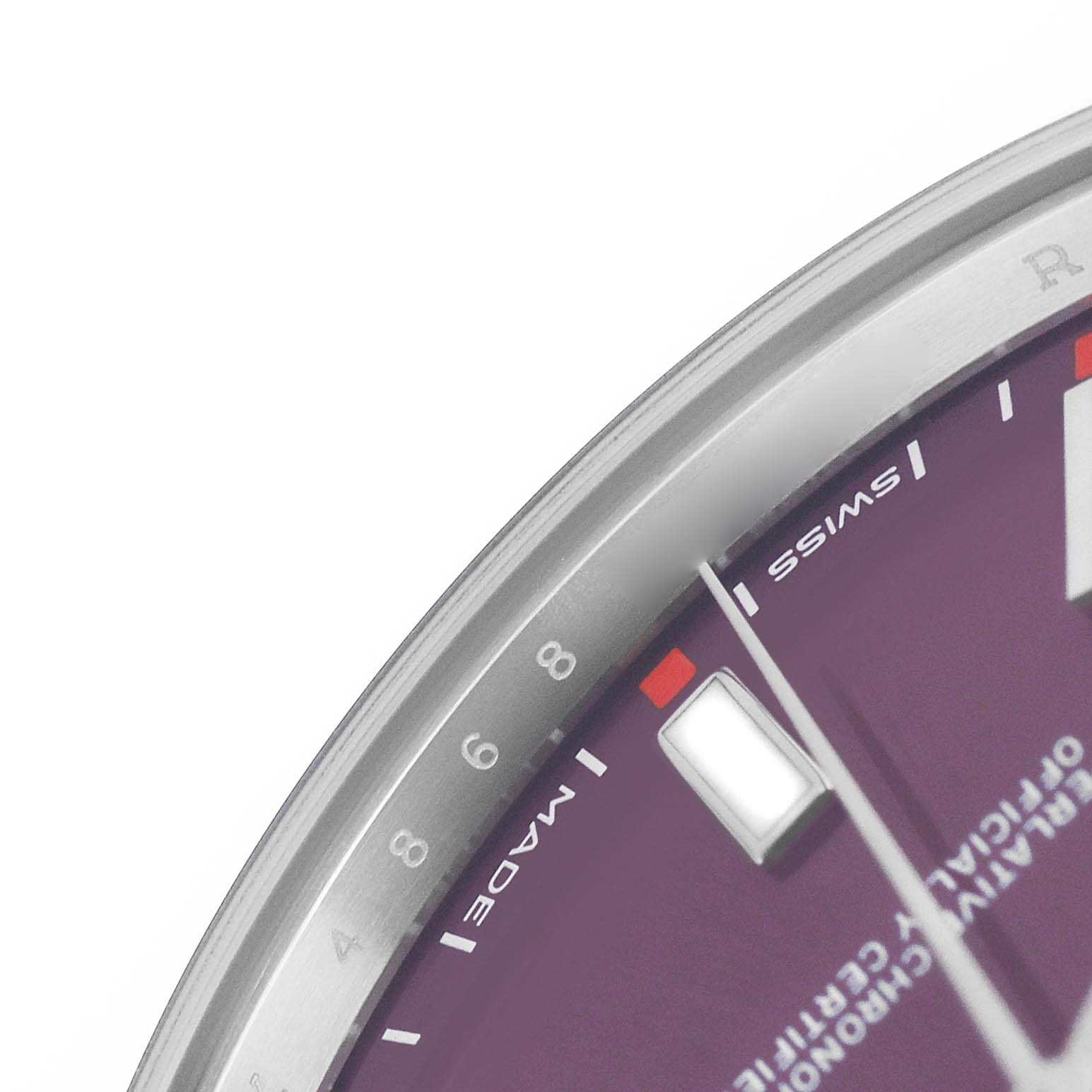 The image shows a close-up of the dial edge and minute markers of a Rolex Oyster Perpetual 114300 Men's Stainless Steel Purple Dial watch.