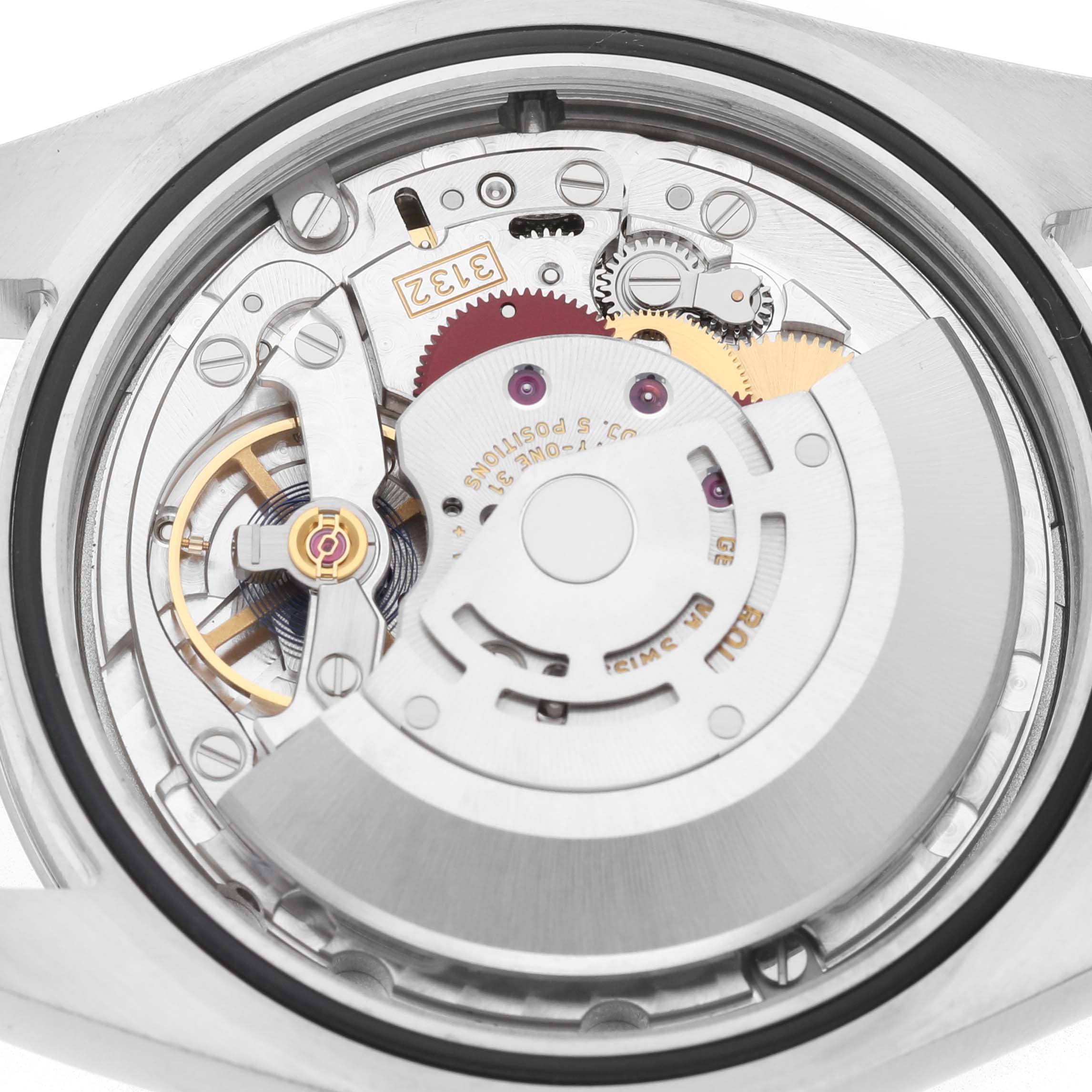 The image shows the movement of a Rolex Oyster Perpetual 114300 Men's Stainless Steel Purple Dial watch, viewed from the back, highlighting the gears and rotor.