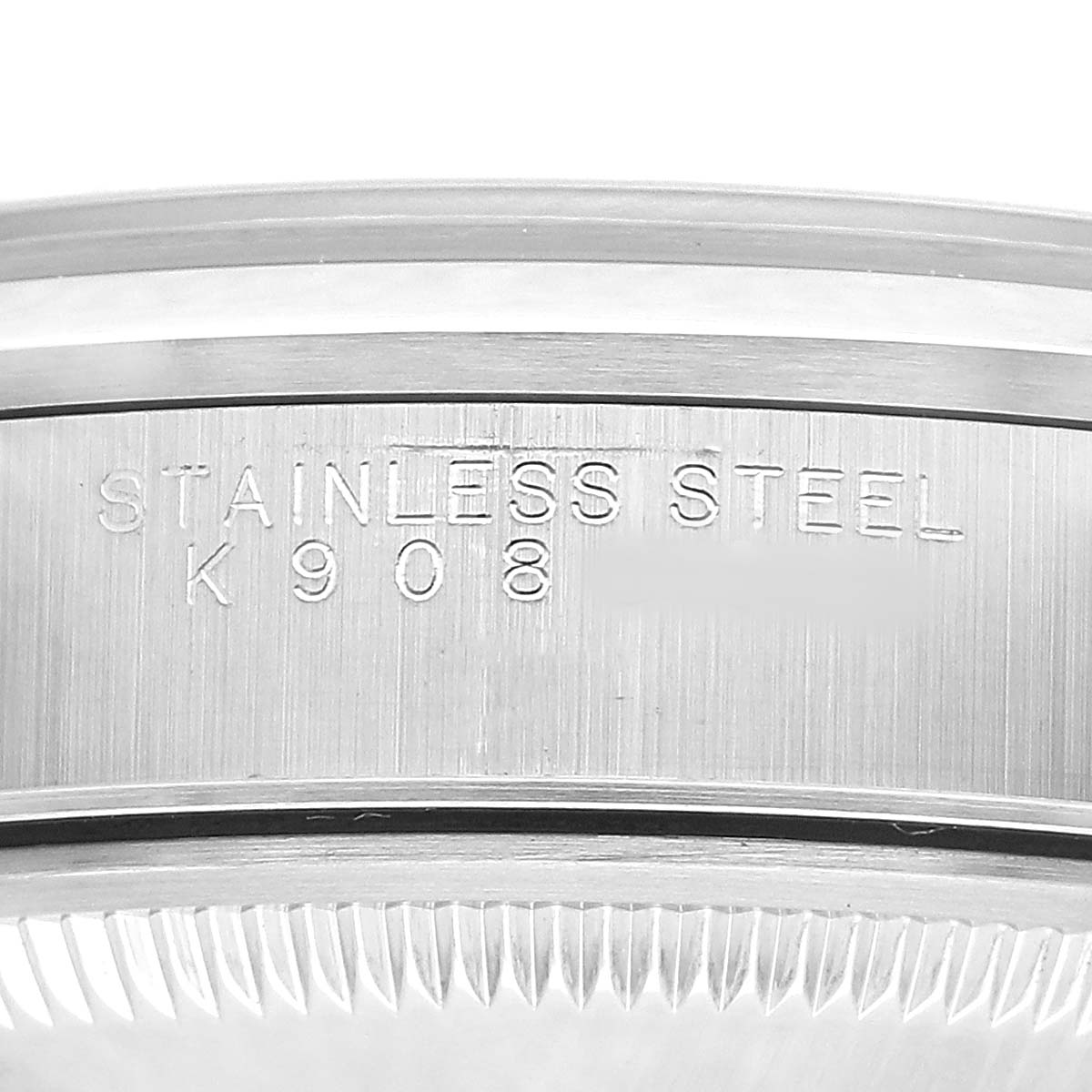 The image shows a close-up of the stainless steel side of the Rolex Oyster Perpetual 15200 Men's Stainless Steel Black Dial watch case, highlighting the engraved text.