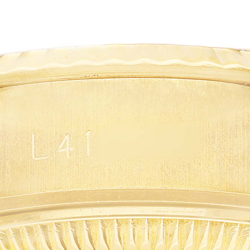 The image shows a close-up of the side of the Rolex President 69178 Women's Yellow Gold Champagne Dial model, focusing on the gold bezel and part of the case with an engraving.