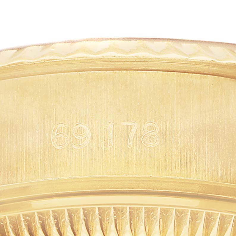 The image shows a close-up of the gold case edge and serial number of the Rolex President 69178 Women's Yellow Gold Champagne Dial model.