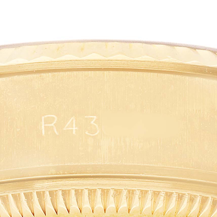 The image shows a close-up of the side of a Rolex President 69178 Women's Yellow Gold Champagne Dial watch, focusing on engravings and the fluted bezel.