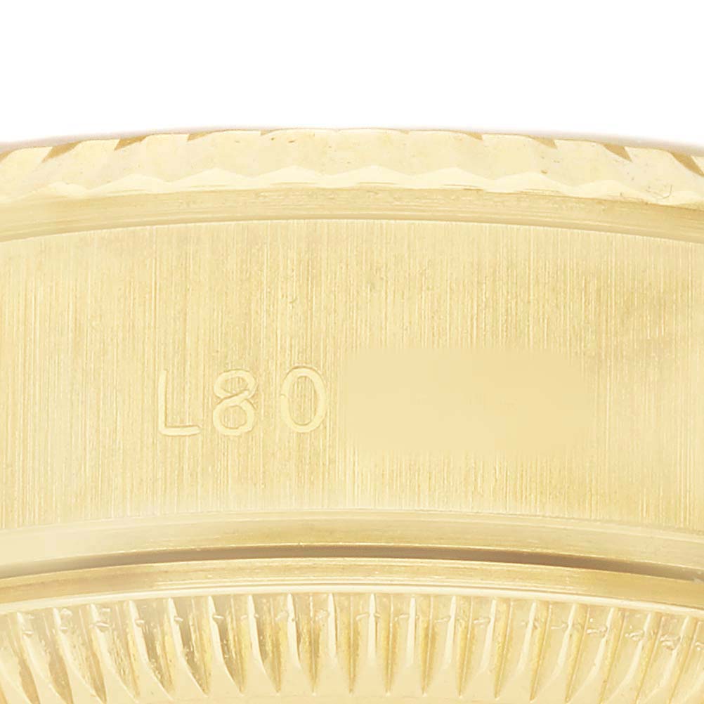 The image shows a close-up of the side of a Rolex Datejust 69178 Women's Yellow Gold Champagne Dial, featuring engravings and the edge of the fluted bezel.
