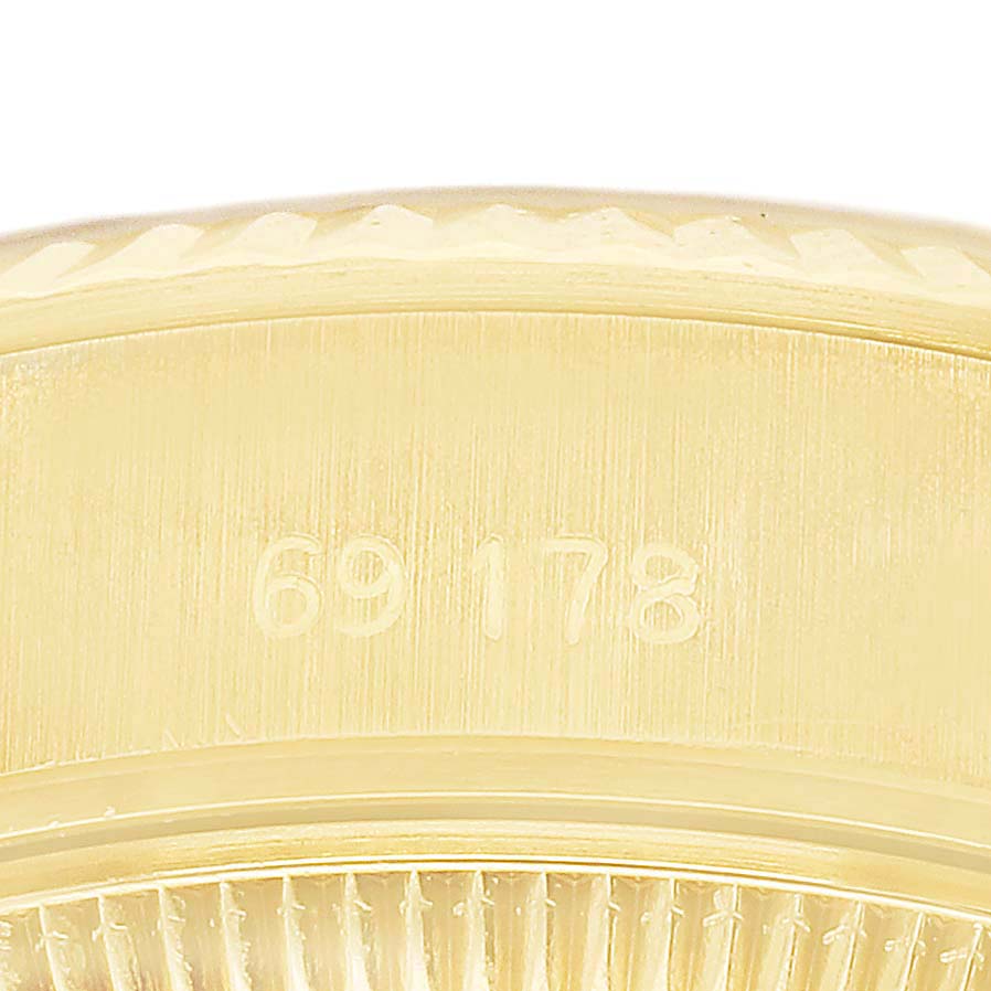 The image shows a close-up view of the Rolex Datejust 69178 Women's Yellow Gold Champagne Dial model's gold fluted bezel and part of the reference number engraved on the side.