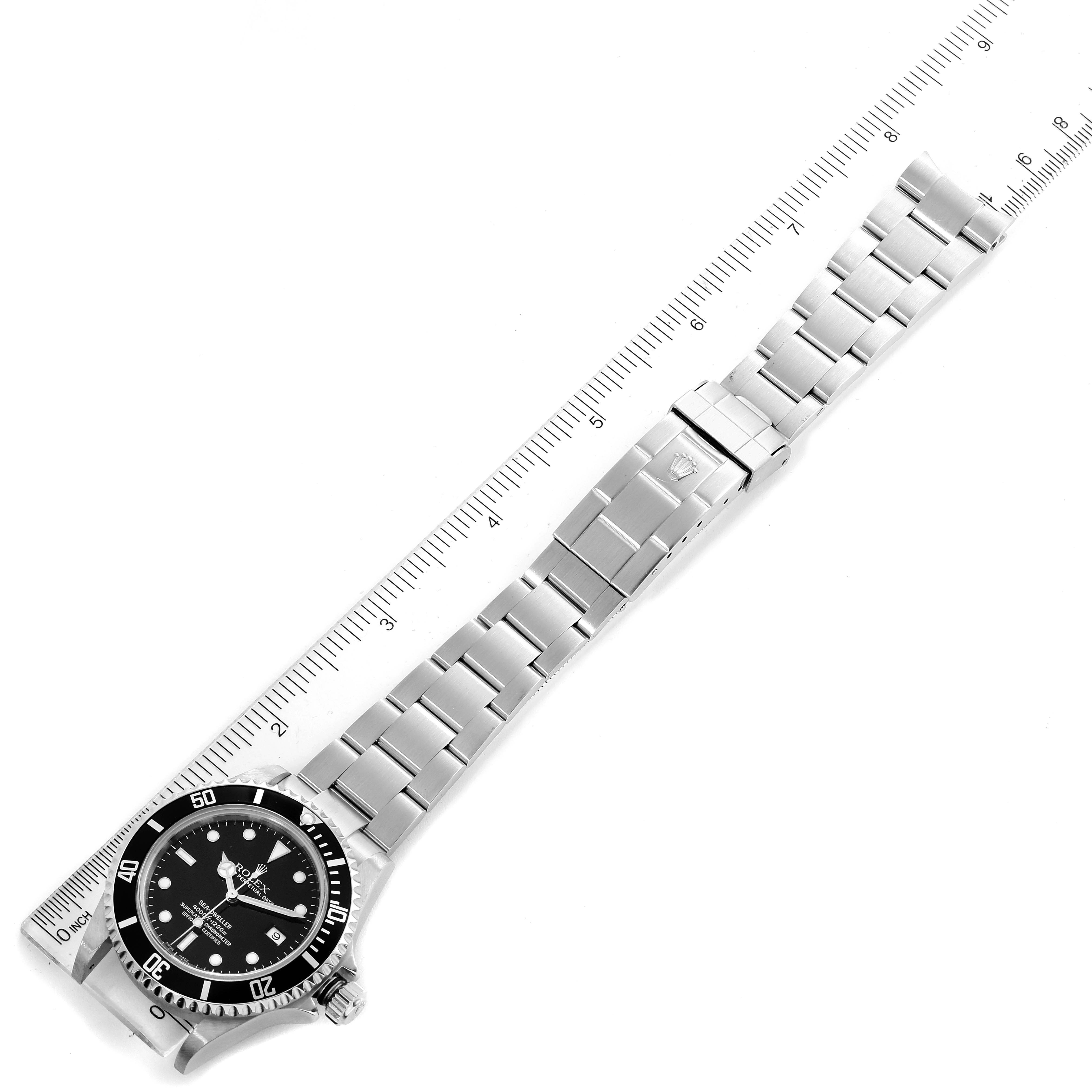The image shows a Rolex Sea-Dweller 16600 Men
s Stainless Steel Black Dial 16600 Men
s Stainless Steel Black Dial watch laid flat with its stainless steel bracelet alongside a ruler for scale.