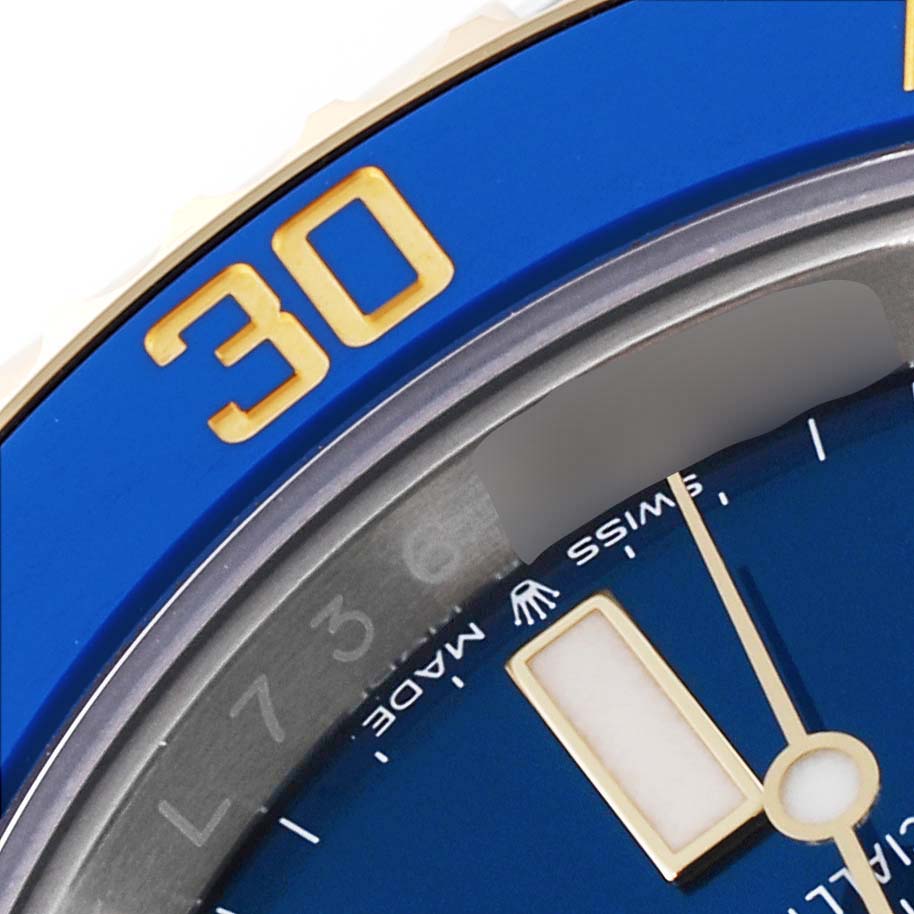 This close-up of the Rolex Submariner 126613 Men's Steel and Gold (two tone) Blue Dial 126613 Men's Steel and Gold (two tone) Blue Dial watch shows the bezel with the number "30" and part of the blue dial with the minute hand.