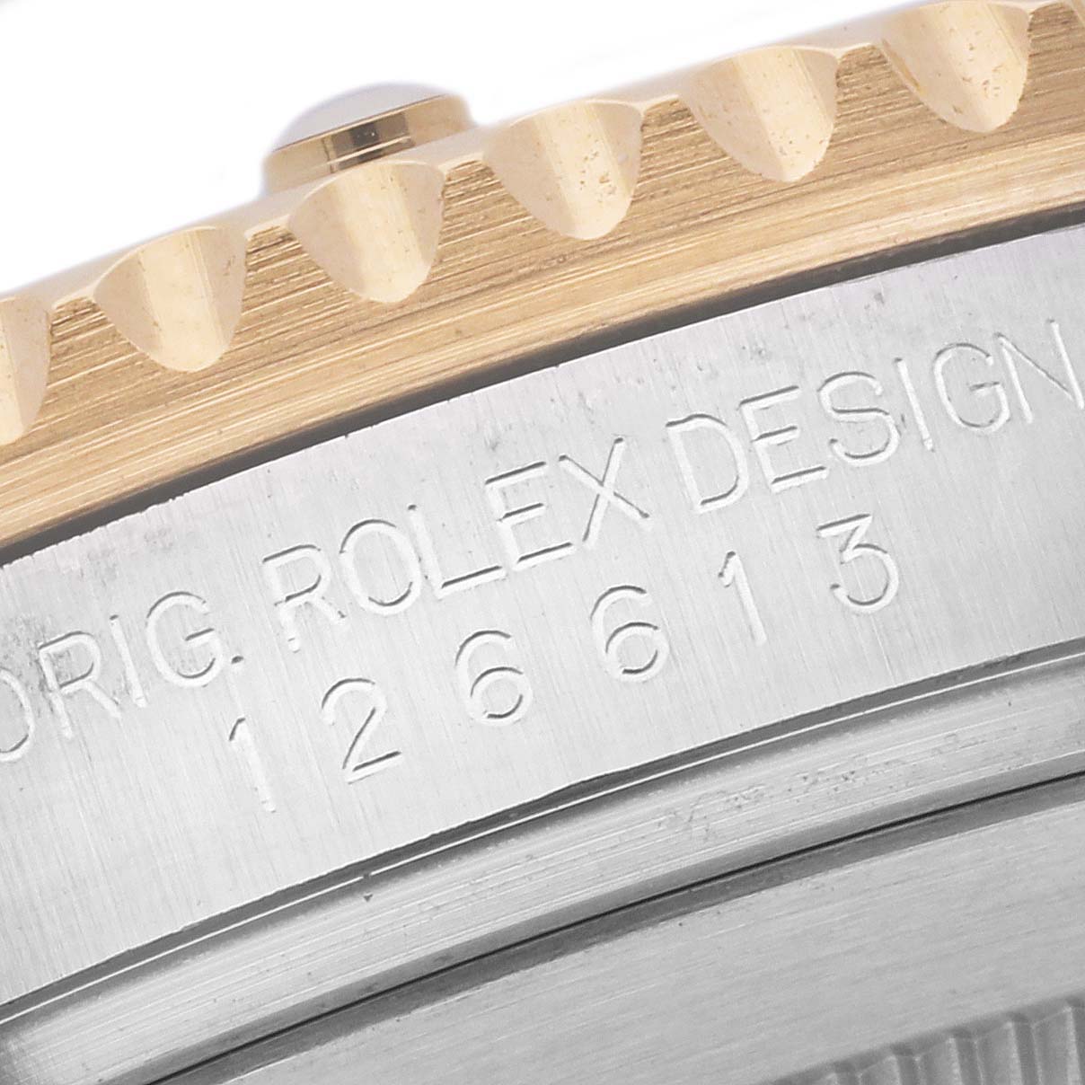 This image shows the engraved side of the case and the edge of the bezel of a Rolex Submariner 126613LB Men's Steel and Gold (two tone) Blue Dial 126613LB Men's Steel and Gold (two tone) Blue Dial watch.