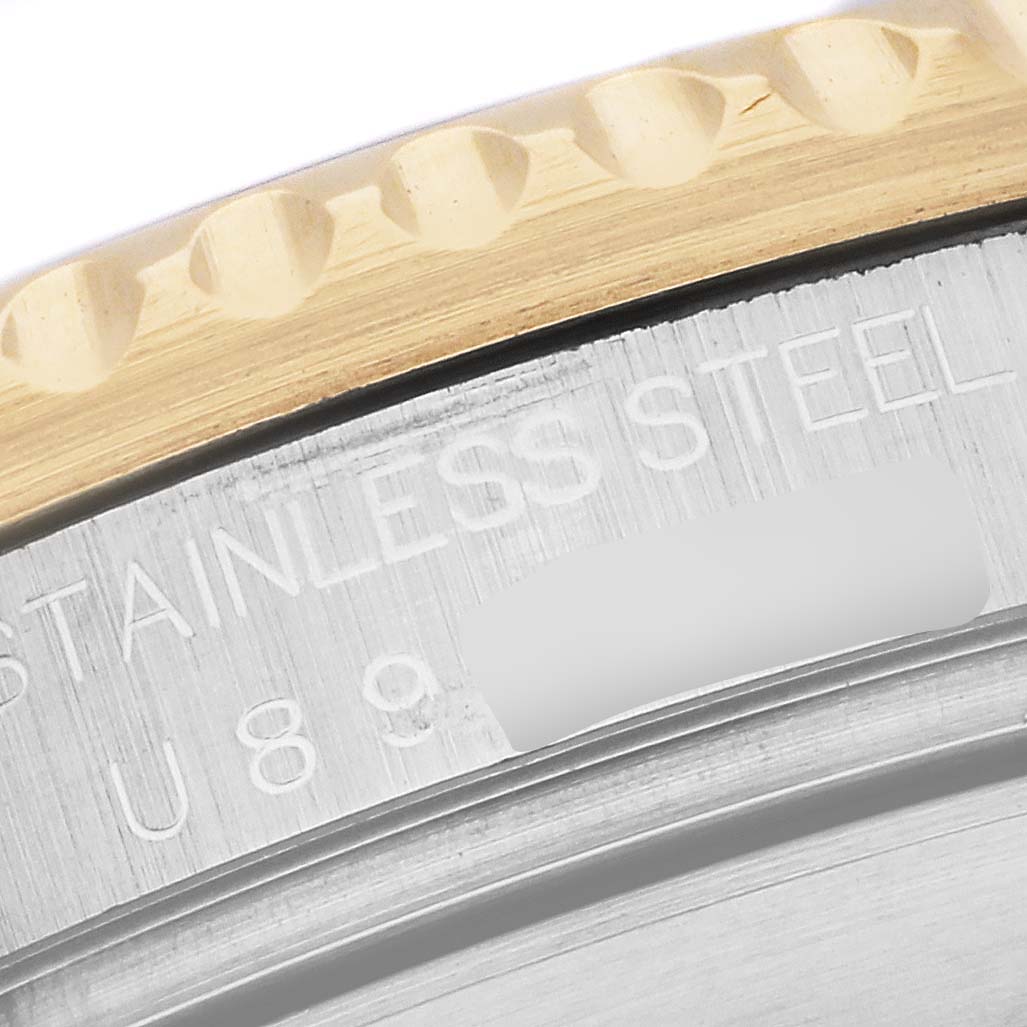 This close-up of the Rolex Submariner 16613 Men's Steel and Gold (two tone) Blue Dial 16613 Men's Steel and Gold (two tone) Blue Dial shows the edge of the watch bezel and part of the case with "STAINLESS STEEL" engraved.