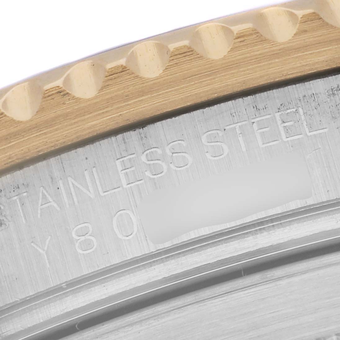 This close-up image shows the edge of the bezel and the engraved case back of a Rolex Submariner 16613 Men's Steel and Gold (two tone) Blue Dial 16613 Men's Steel and Gold (two tone) Blue Dial watch.
