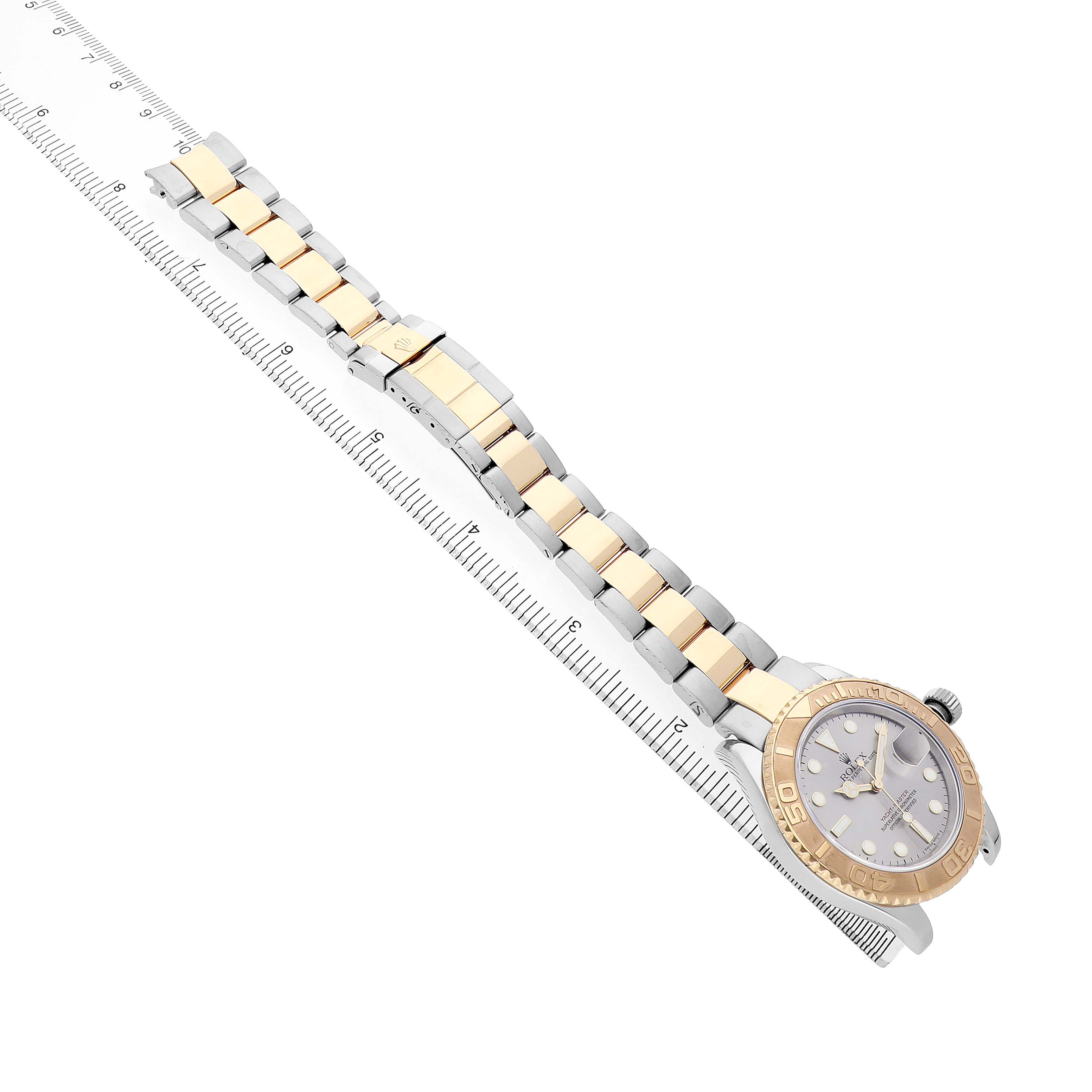 The Rolex Yacht-Master 16623 Men's Steel and Gold (two tone) Grey Dial watch is shown from an angled top view, displaying its face, metal bracelet, and a ruler for scale.