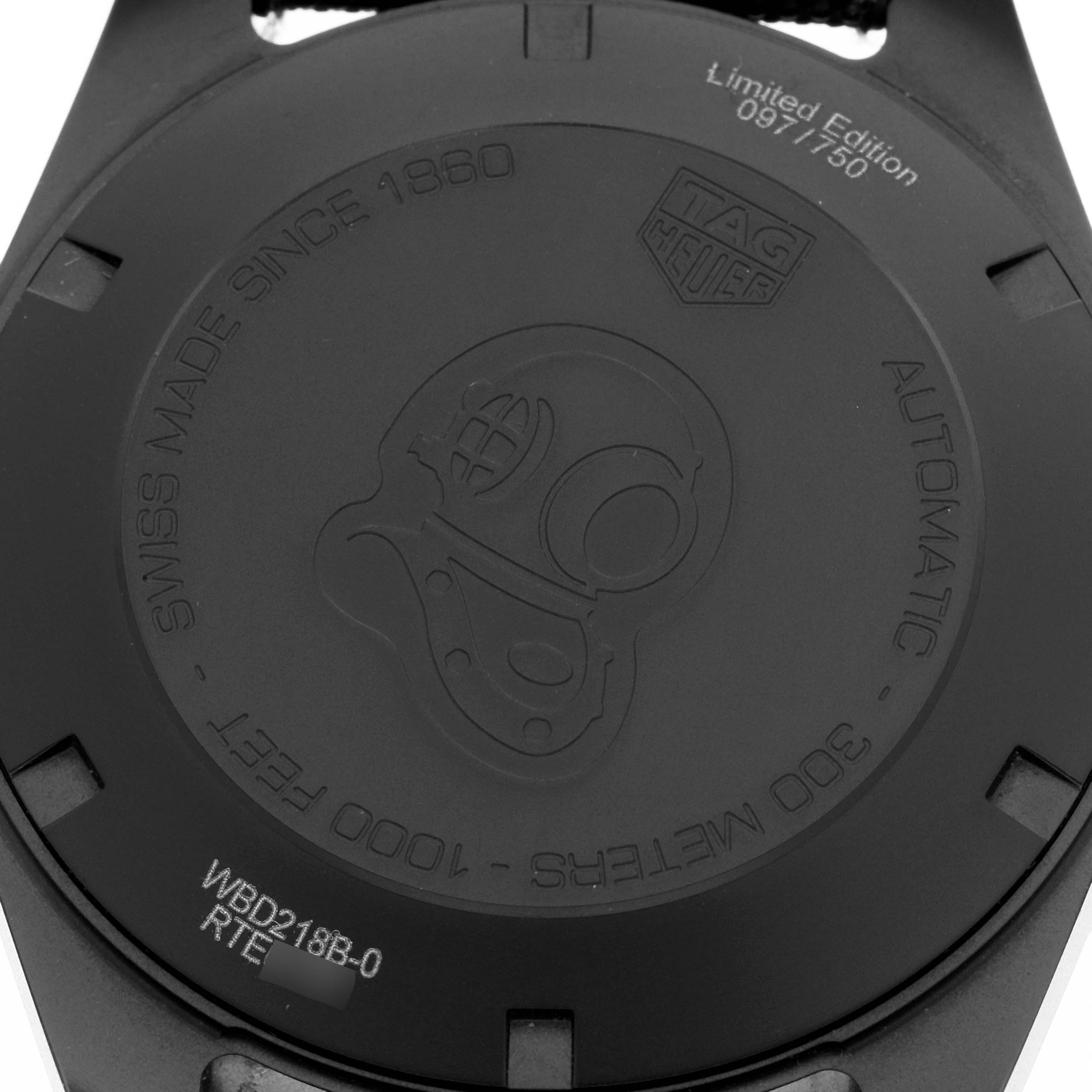 The image shows the case back of a Tag Heuer Aquaracer WBD218B.FC6446 Men
s Titanium Black Dial WBD218B.FC6446 Men
s Titanium Black Dial watch, featuring engraved text and a diver helmet design.