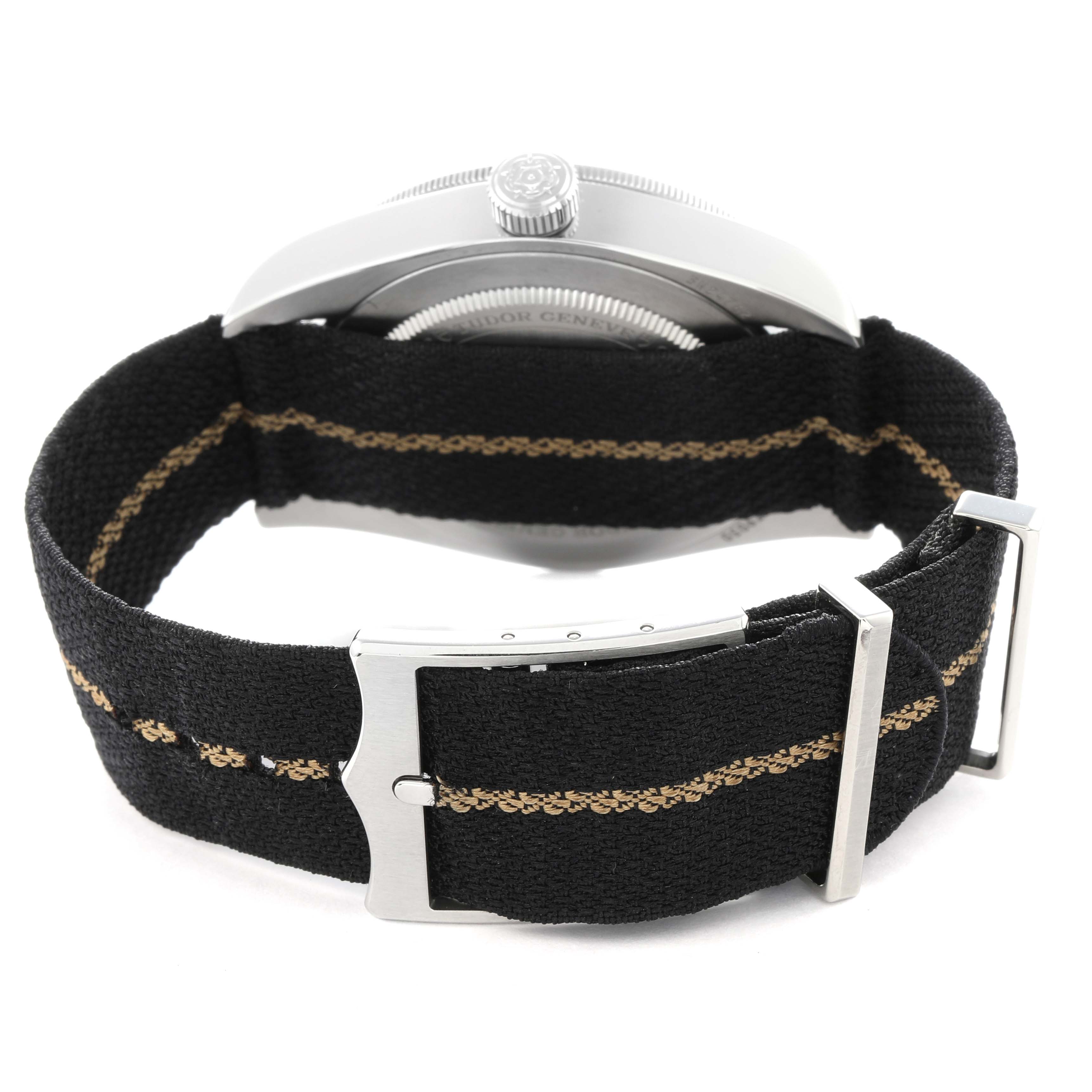 The image shows the Tudor Heritage Black Bay 79030 Men
s Stainless Steel Black Dial 79030 Men
s Stainless Steel Black Dial watch
s side view, highlighting the strap, clasp, and crown.