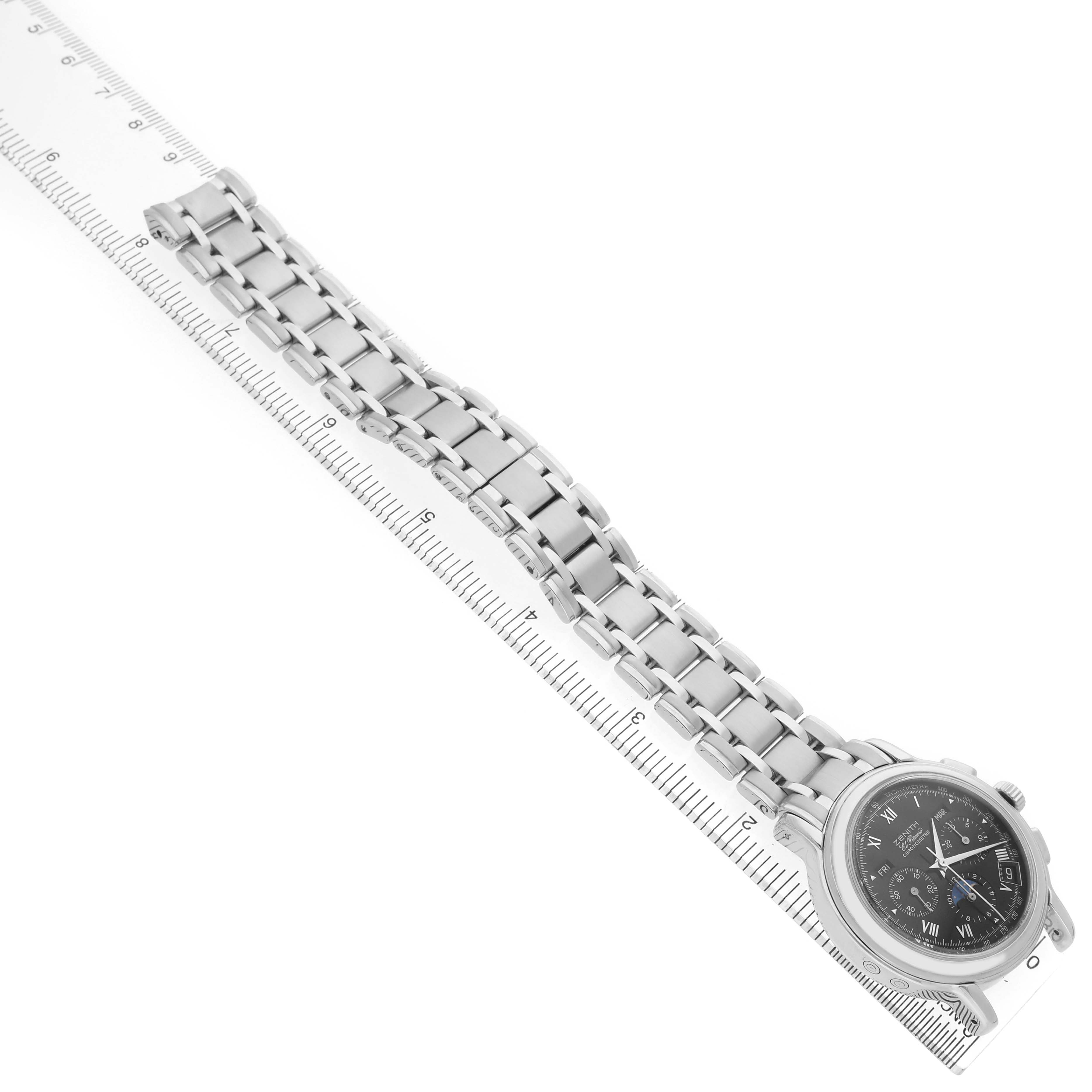 The Zenith El Primero 02.0240.410/21 Men's Stainless Steel Black Dial watch is shown laid flat at a diagonal angle, displaying the face and full metal band alongside a ruler.