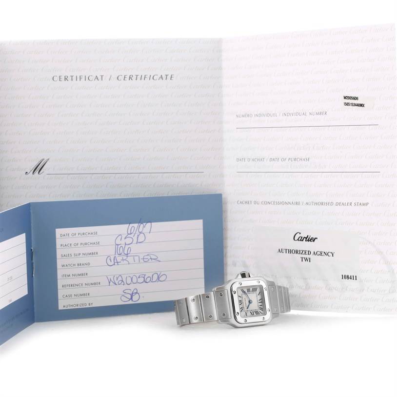 The image shows a Cartier Santos W20056D6 Women
s Stainless Steel Silver Dial W20056D6 Women
s Stainless Steel Silver Dial watch and accompanying certificates, displayed at a slight angle.