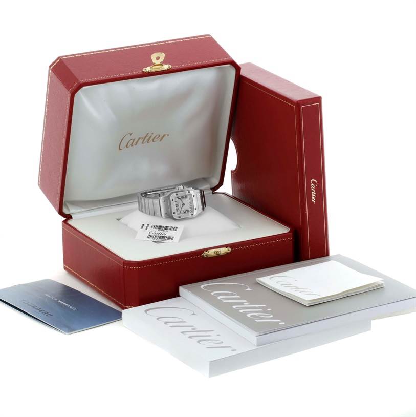 The image shows a Cartier Santos W20056D6 Women
s Stainless Steel Silver Dial W20056D6 Women
s Stainless Steel Silver Dial watch in a red box along with its manuals and booklets.