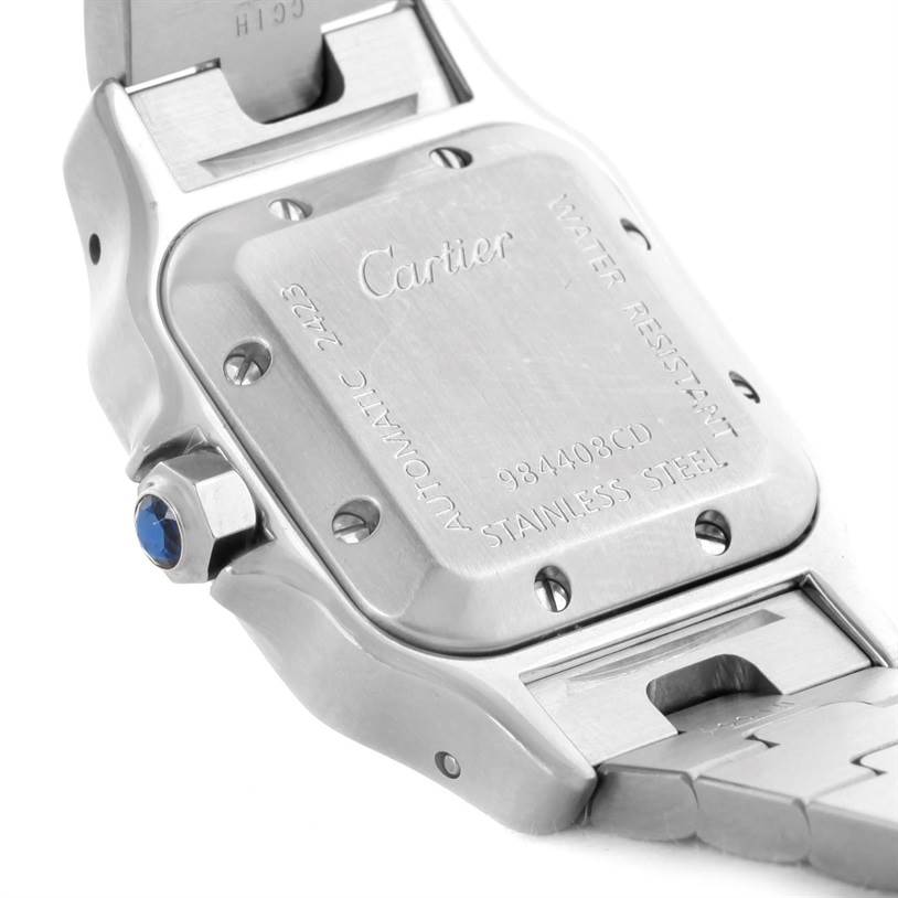 The image shows the back case and part of the bracelet of a Santos model by Cartier, along with the crown featuring a blue gem.