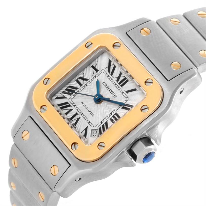 This image shows a close-up of the Cartier Santos W20057C4 Women
s Stainless Steel Silver Dial W20057C4 Women
s Stainless Steel Silver Dial watch, highlighting the face, bezel, part of the bracelet, and the crown.