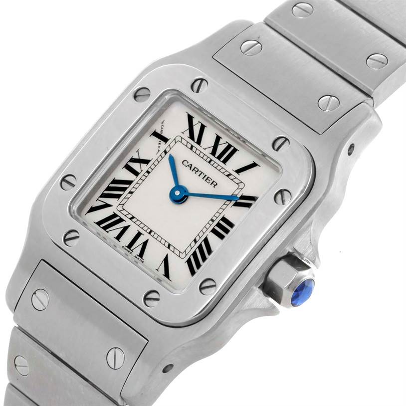 The image shows a close-up of a Cartier Santos W20056D6 Women
s Stainless Steel Silver Dial W20056D6 Women
s Stainless Steel Silver Dial watch
s dial and part of the bracelet at an angled view.