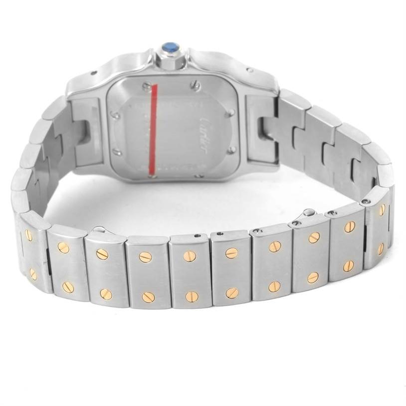 The image shows the Santos model by Cartier from a rear angle, highlighting its back case, chain links, and gold screw details.