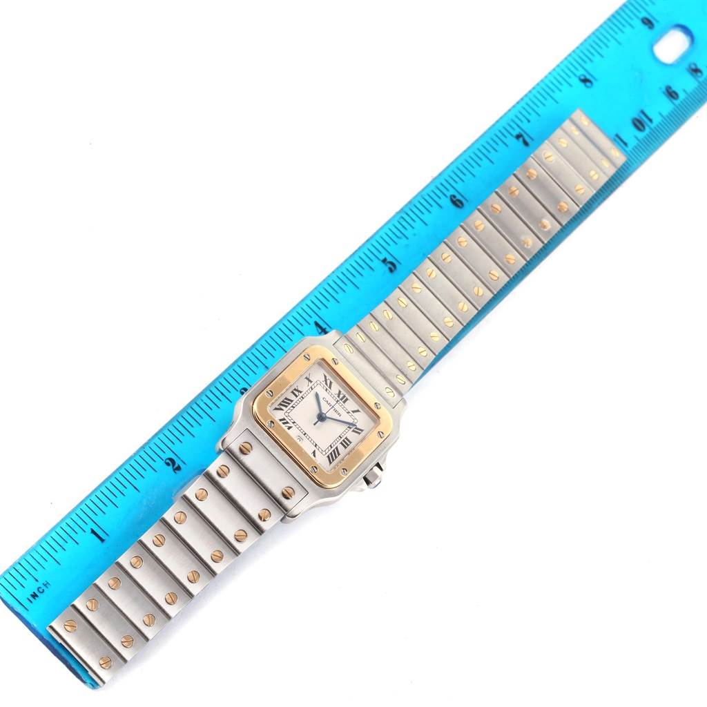 The Cartier Santos W20011C4 Stainless Steel Silver Dial W20011C4 Stainless Steel Silver Dial watch is displayed flat, showing the face, bezel, bracelet, and part of a ruler for scale.