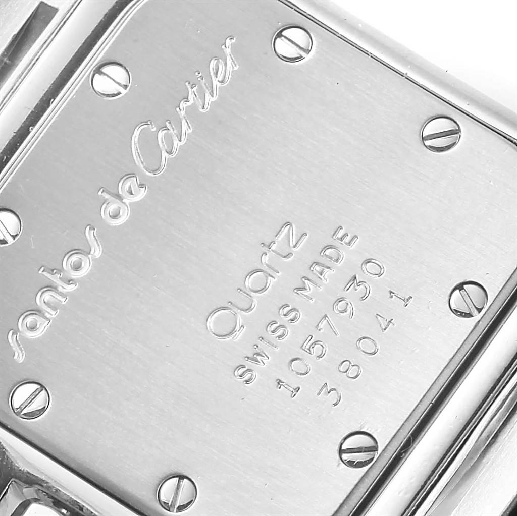 The image shows the back case of a Santos model watch by Cartier, showcasing engravings and screws.