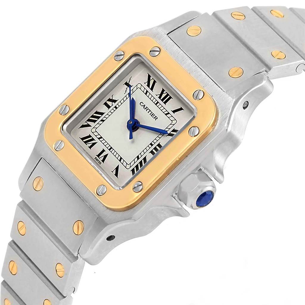 The image shows a close-up of the Santos model by Cartier, highlighting the face, bracelet, and crown from an angled view.