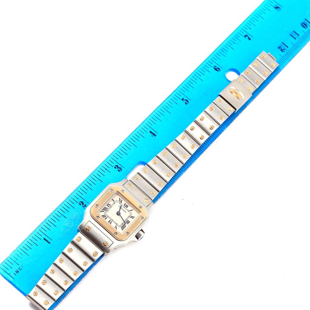 This image shows a Cartier Santos 1567 Women's Stainless Steel Silver Dial 1567 Women's Stainless Steel Silver Dial watch laid flat next to a ruler, displaying its face and full bracelet.