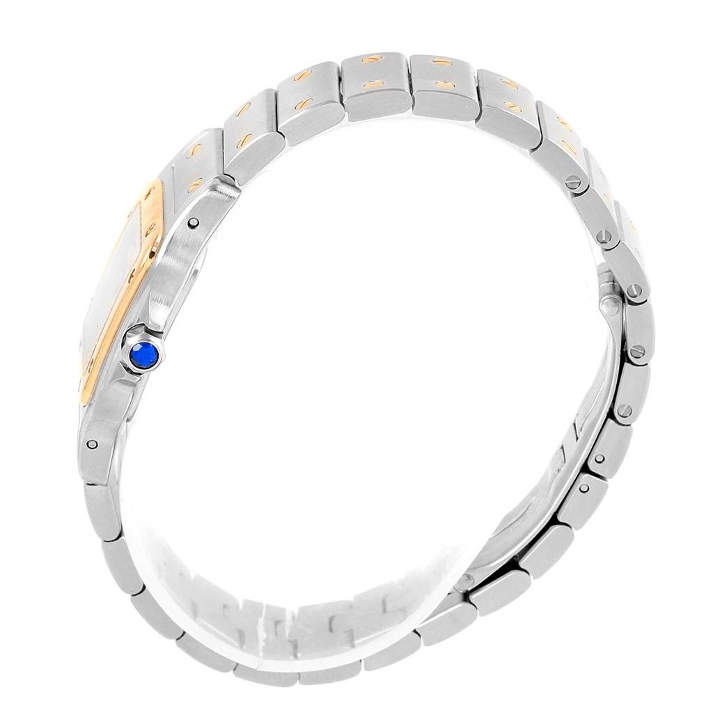 The image shows a side view of a Cartier Santos W20012C4 Women's Stainless Steel Silver Dial W20012C4 Women's Stainless Steel Silver Dial watch, highlighting its metal bracelet and the crown with a blue sapphire.