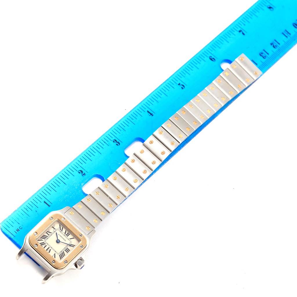 This image shows the Cartier Santos W20012C4 Women's Stainless Steel Silver Dial W20012C4 Women's Stainless Steel Silver Dial watch laid flat with its bracelet stretched out, measured against a blue ruler.