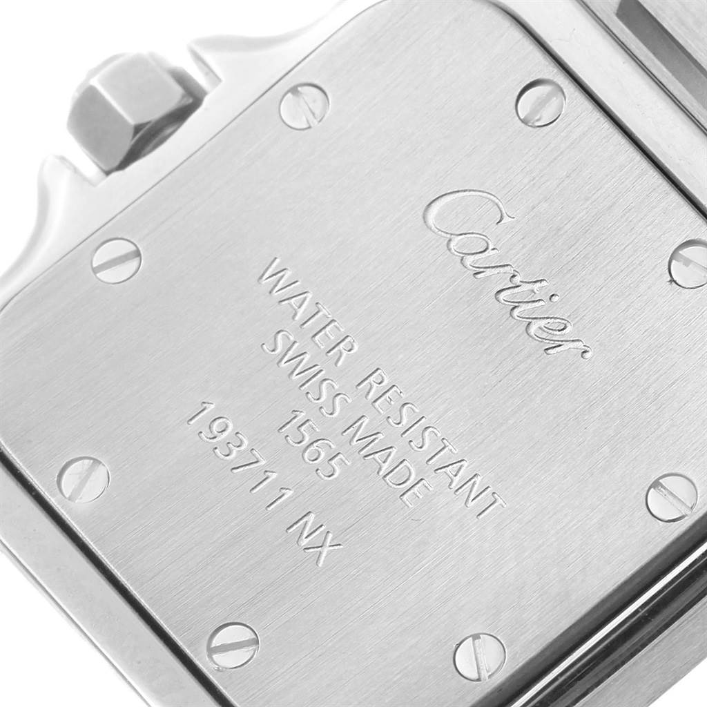This image shows the back case of a Santos watch by Cartier from a close-up angle, detailing the engravings.