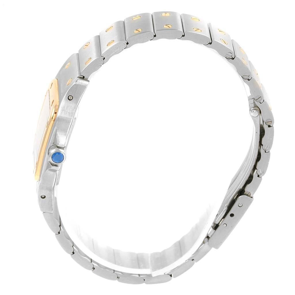 The image shows a side profile of a Cartier Santos 1567 Women's Stainless Steel Silver Dial 1567 Women's Stainless Steel Silver Dial model watch, highlighting the gold bezel, metal bracelet, and crown with a blue cabochon.