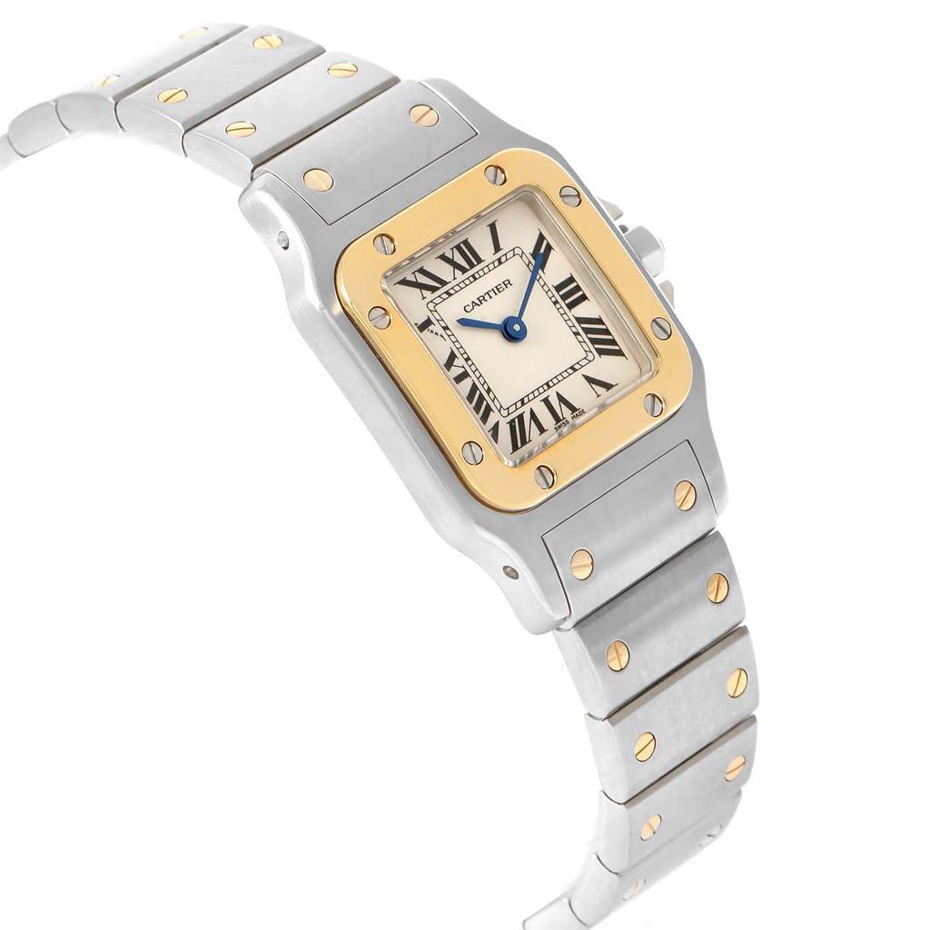 The Cartier Santos W20012C4 Women's Stainless Steel Silver Dial W20012C4 Women's Stainless Steel Silver Dial watch is shown at a slight angle, highlighting its rectangular face, gold bezel, and metallic bracelet with gold screws.