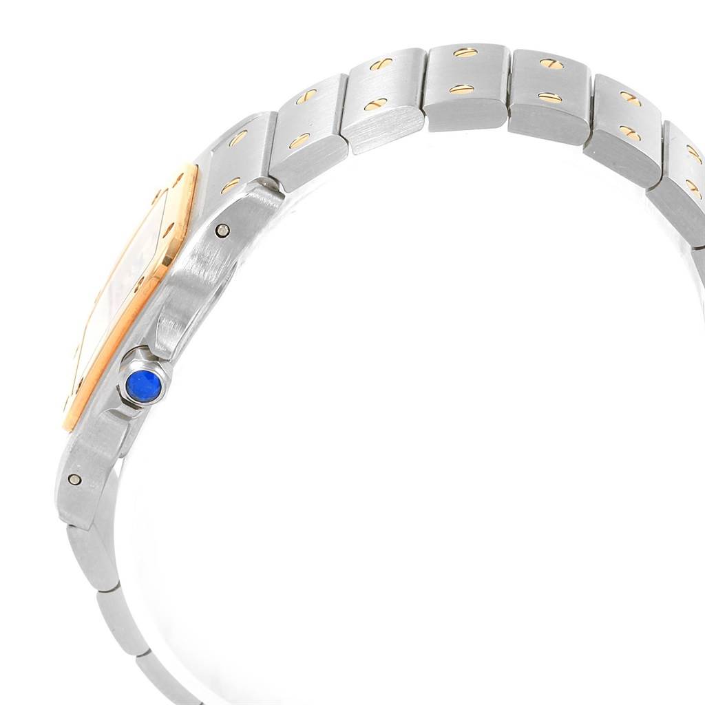 The image shows a side angle of the Cartier Santos W20012C4 Women's Stainless Steel Silver Dial W20012C4 Women's Stainless Steel Silver Dial watch, highlighting its band and crown with a blue gem.