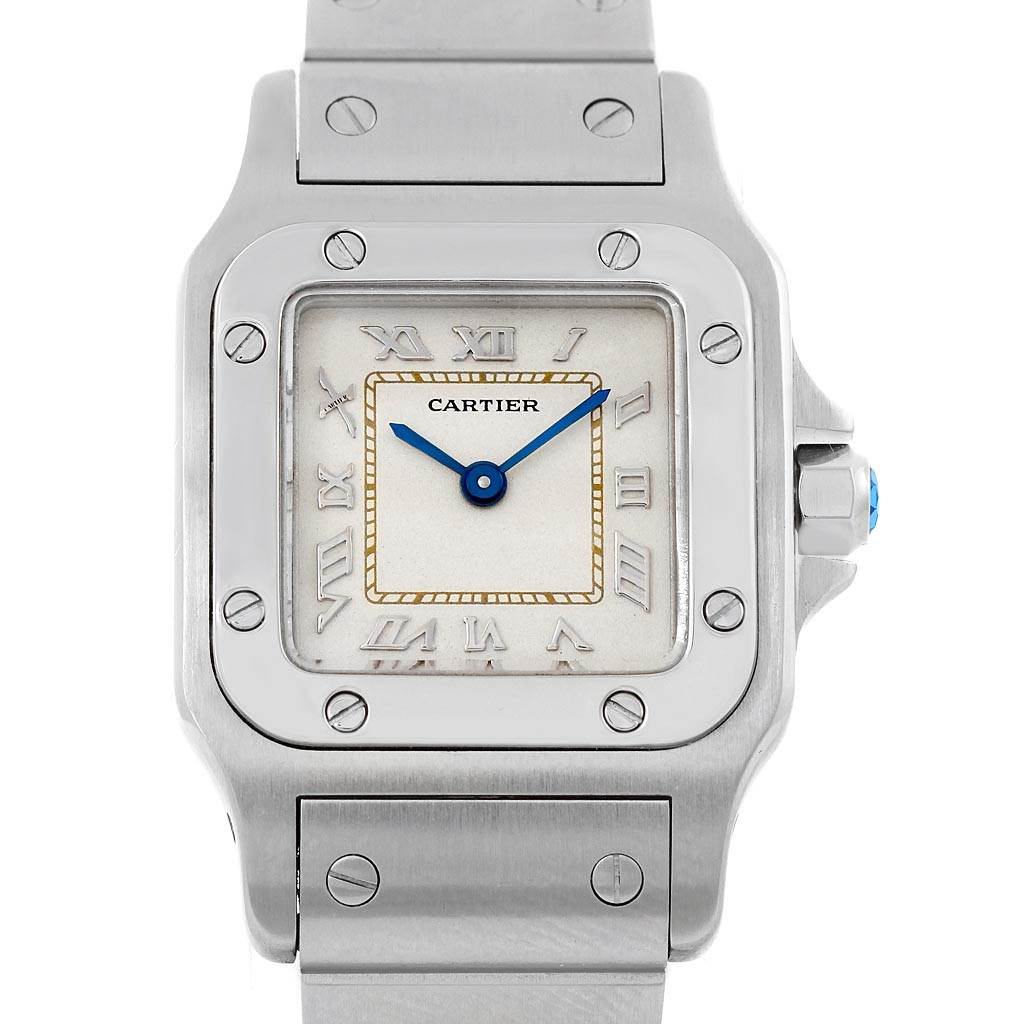 The image displays a close-up, front view of the Cartier Santos 1565 Women's Stainless Steel Silver Dial 1565 Women's Stainless Steel Silver Dial watch, highlighting the face, bezel, and part of the bracelet.