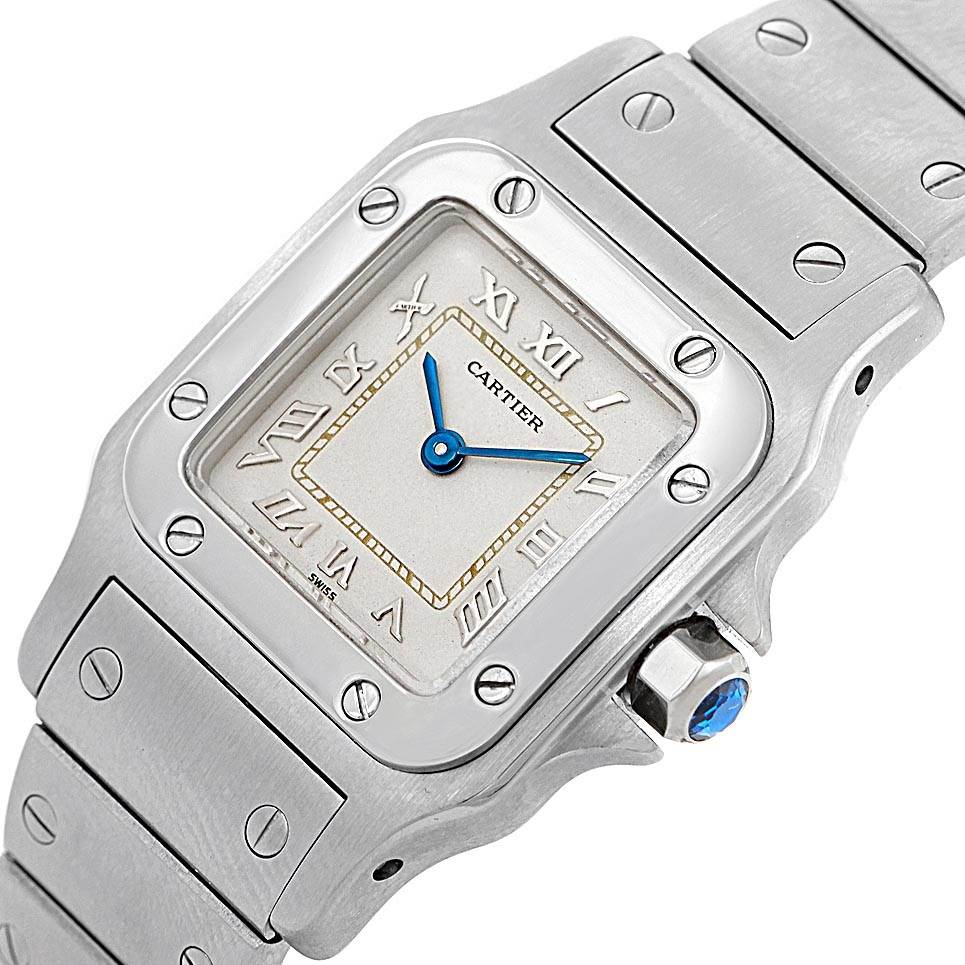 The image shows a close-up, angled view of the Cartier Santos 1565 Women's Stainless Steel Silver Dial 1565 Women's Stainless Steel Silver Dial watch face and part of the bracelet.